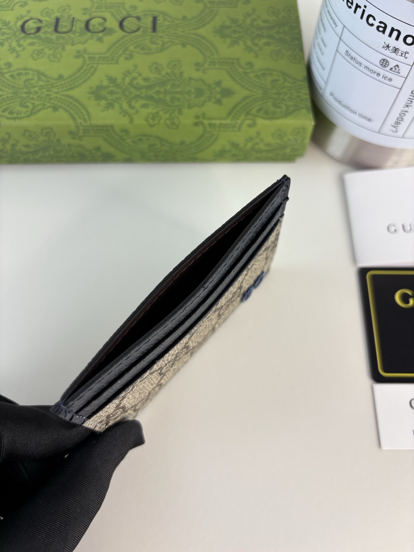 GUCCl 这款卡片夹采用米色和乌木色GG Supreme帆布精制而成，品牌典藏细节尽展高雅韵致。采用小巧GG配件细节，