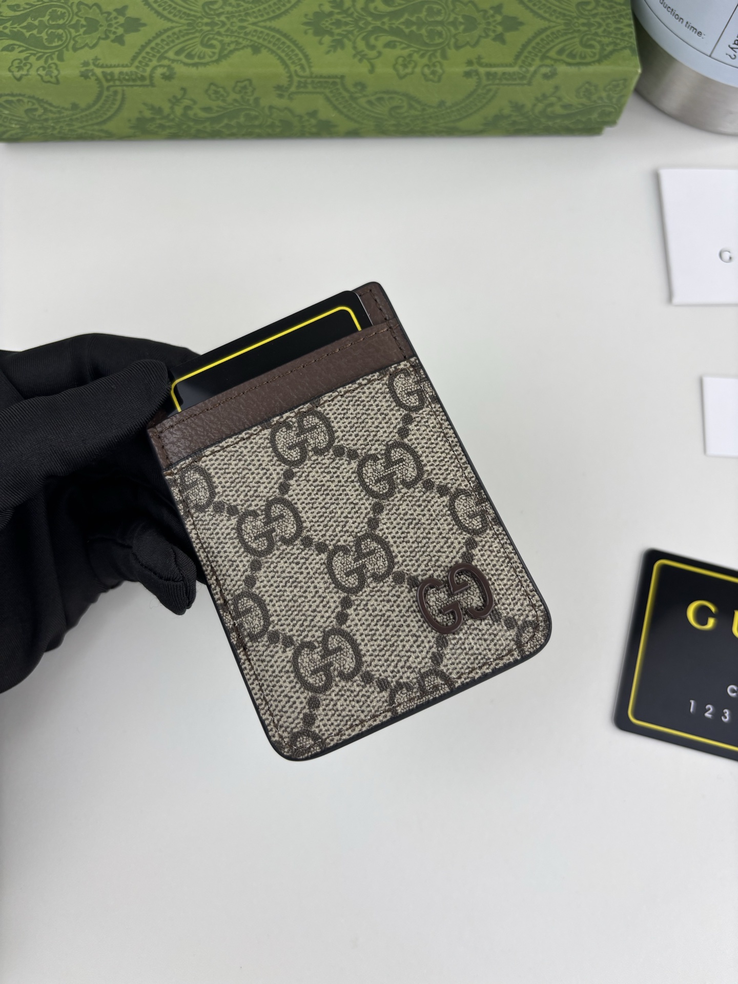 GUCUl新系列呈现纤薄且小巧的皮具作品，焕新融蕴多种色彩，GG标识点缀充满对比美感的双色调设计。这款磁扣卡片夹以啡色和