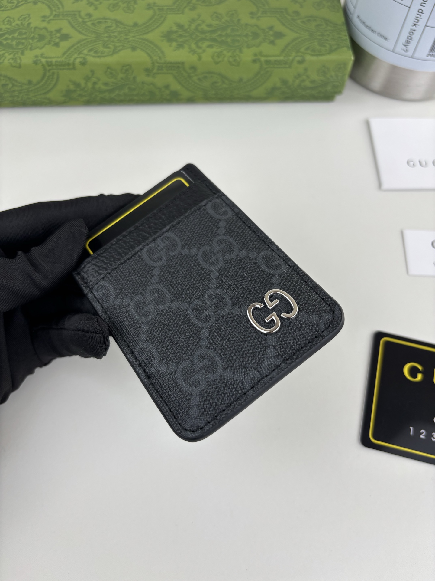 GUCUl新系列呈现纤薄且小巧的皮具作品，焕新融蕴多种色彩，GG标识点缀充满对比美感的双色调设计。这款磁扣卡片夹以黑色和