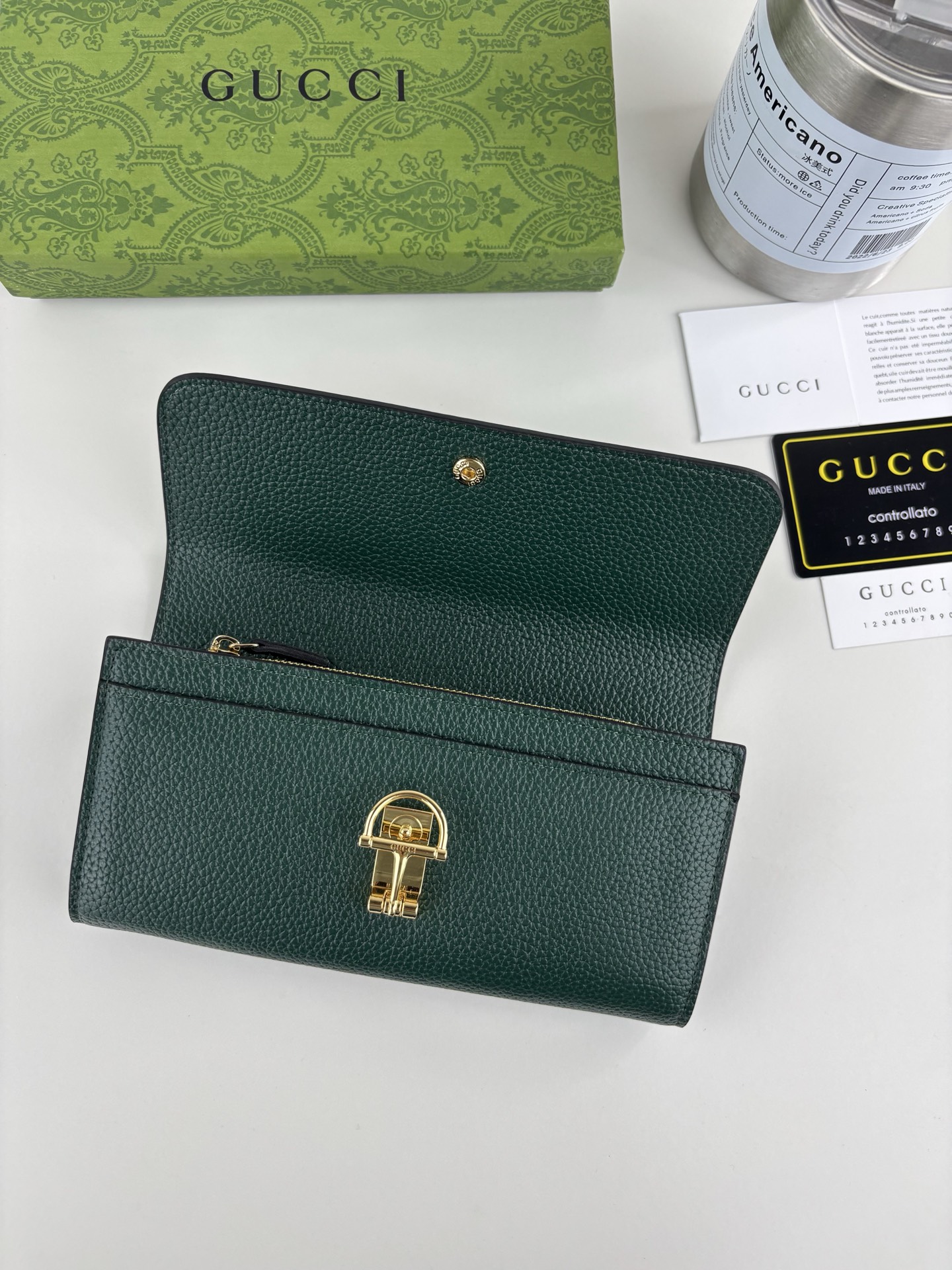 GUCCl 延续品牌深厚传承，深化与马术本源的联结。半马衔扣图案化身为开合细节，为多款小皮件增色添彩。这款长夹以绿色粒面
