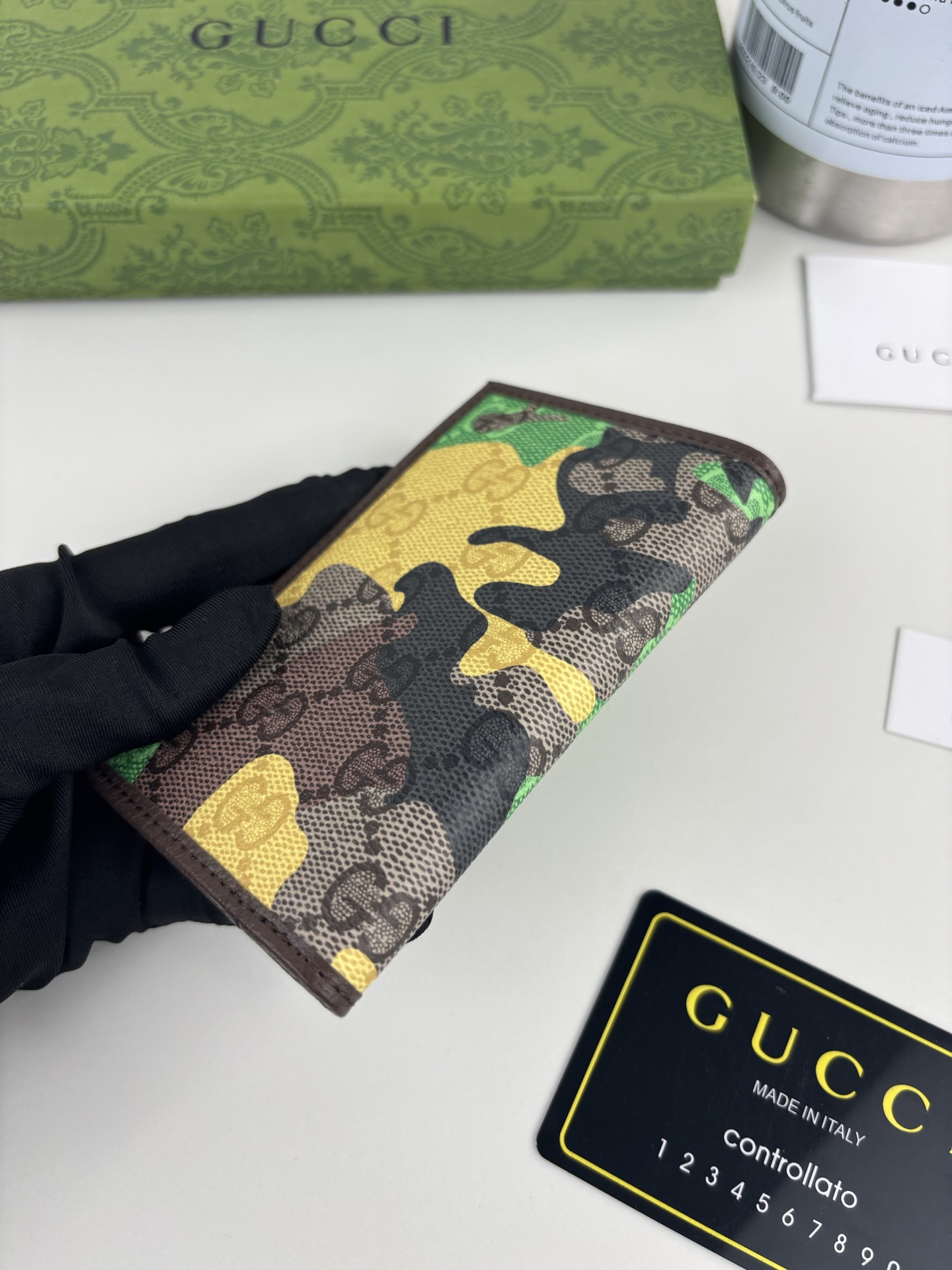 GUCCl生动迷彩结合别致配色，焕新演绎经典GG图案。这款长款卡片夹以大理石纹GG字母图案涂层织物打造，匠心融蕴双G细节