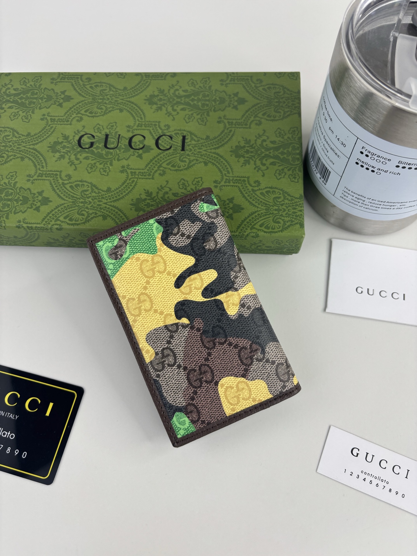 GUCCl生动迷彩结合别致配色，焕新演绎经典GG图案。这款长款卡片夹以大理石纹GG字母图案涂层织物打造，匠心融蕴双G细节