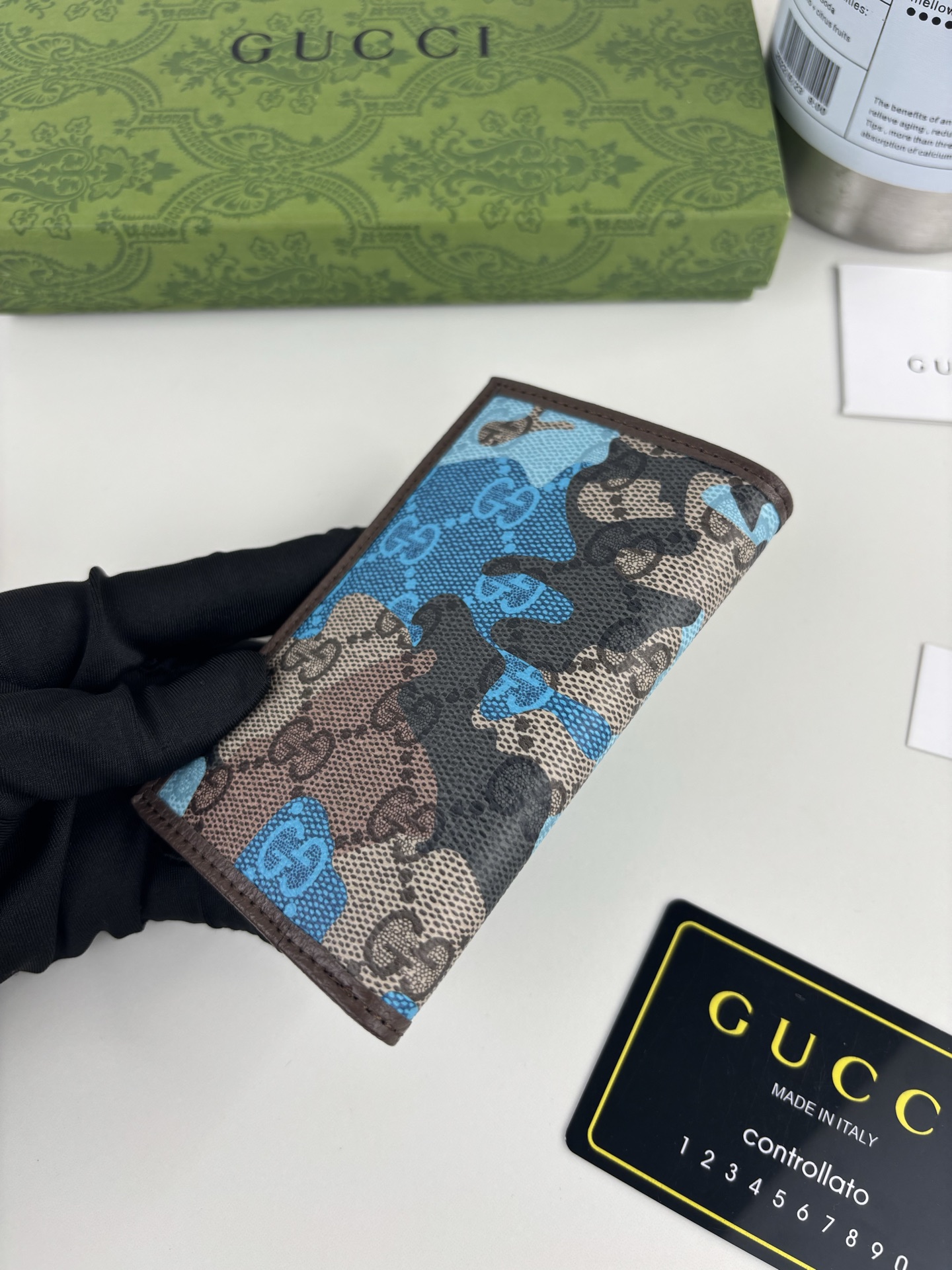 GUCCl生动迷彩结合别致配色，焕新演绎经典GG图案。这款长款卡片夹以大理石纹GG字母图案涂层织物打造，匠心融蕴双G细节