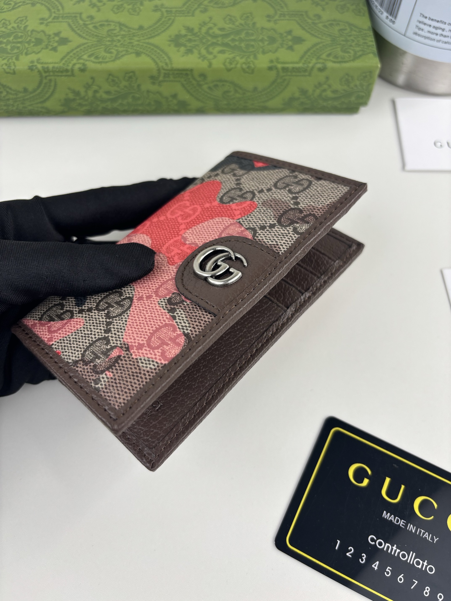 GUCCl生动迷彩结合别致配色，焕新演绎经典GG图案。这款长款卡片夹以大理石纹GG字母图案涂层织物打造，匠心融蕴双G细节