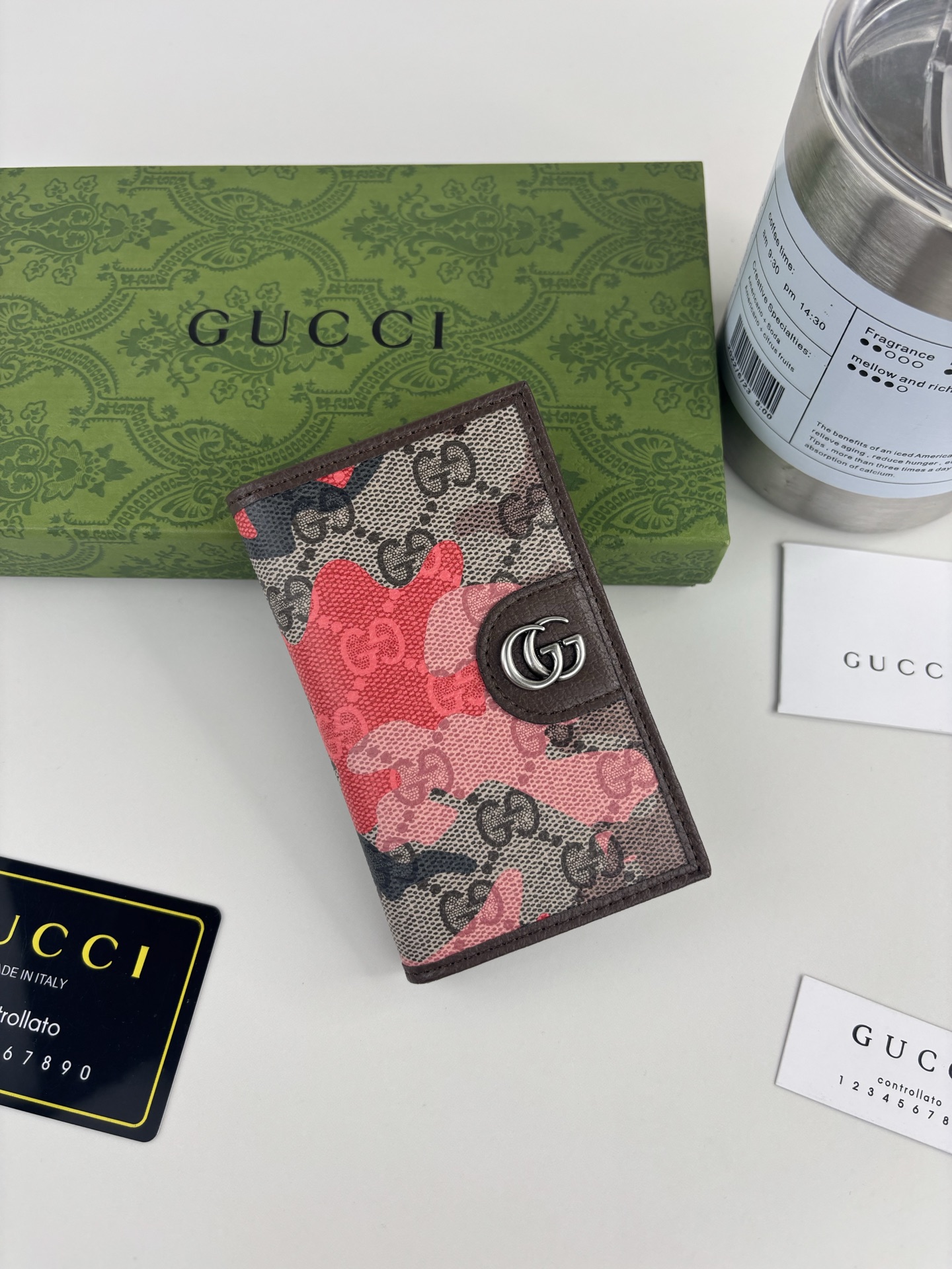 GUCCl生动迷彩结合别致配色，焕新演绎经典GG图案。这款长款卡片夹以大理石纹GG字母图案涂层织物打造，匠心融蕴双G细节