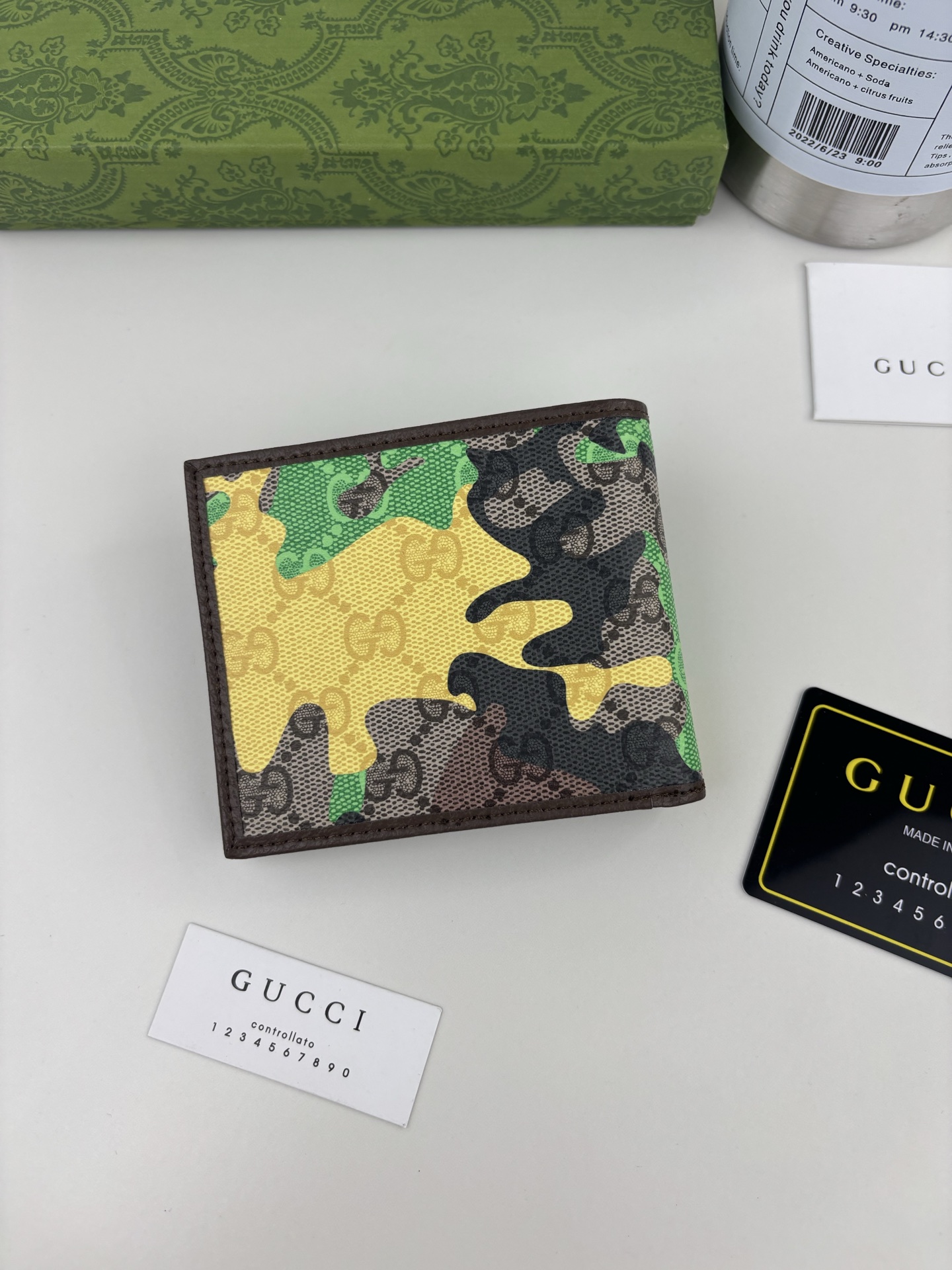 GUCCl生动迷彩结合别致配色，焕新演绎经典GG图案。这款双折包以大理石纹GG字母图案涂层织物打造，匠心融蕴双G细节。 