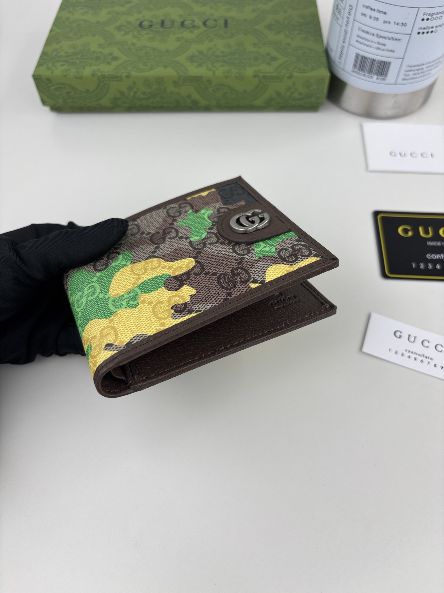 GUCCl生动迷彩结合别致配色，焕新演绎经典GG图案。这款双折包以大理石纹GG字母图案涂层织物打造，匠心融蕴双G细节。 