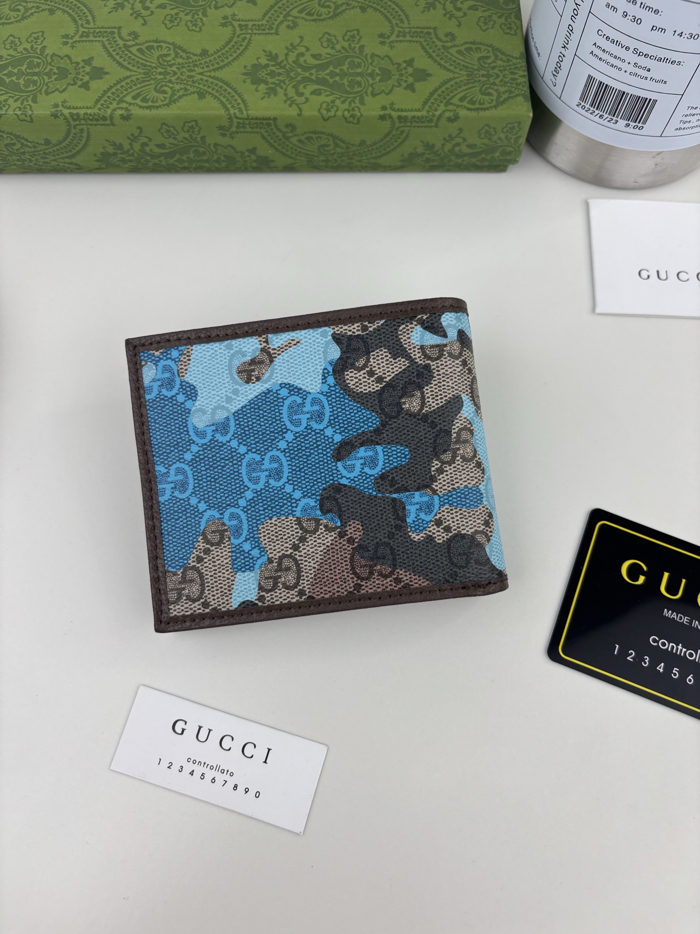 GUCCl生动迷彩结合别致配色，焕新演绎经典GG图案。这款双折包以大理石纹GG字母图案涂层织物打造，匠心融蕴双G细节。 