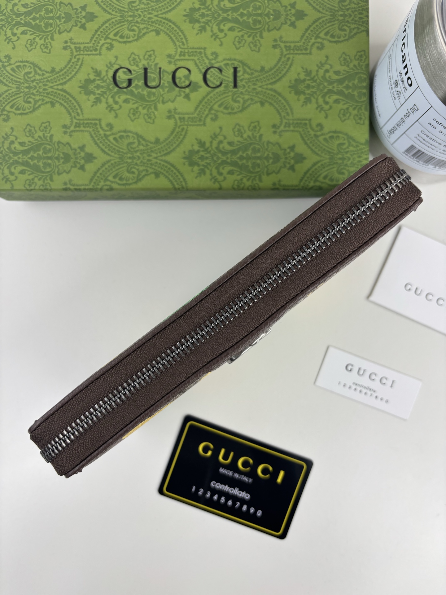 GUCCl生动迷彩结合别致配色，焕新演绎经典GG图案。这款全拉链钱包以大理石纹GG字母图案涂层织物打造，匠心融蕴双G细节