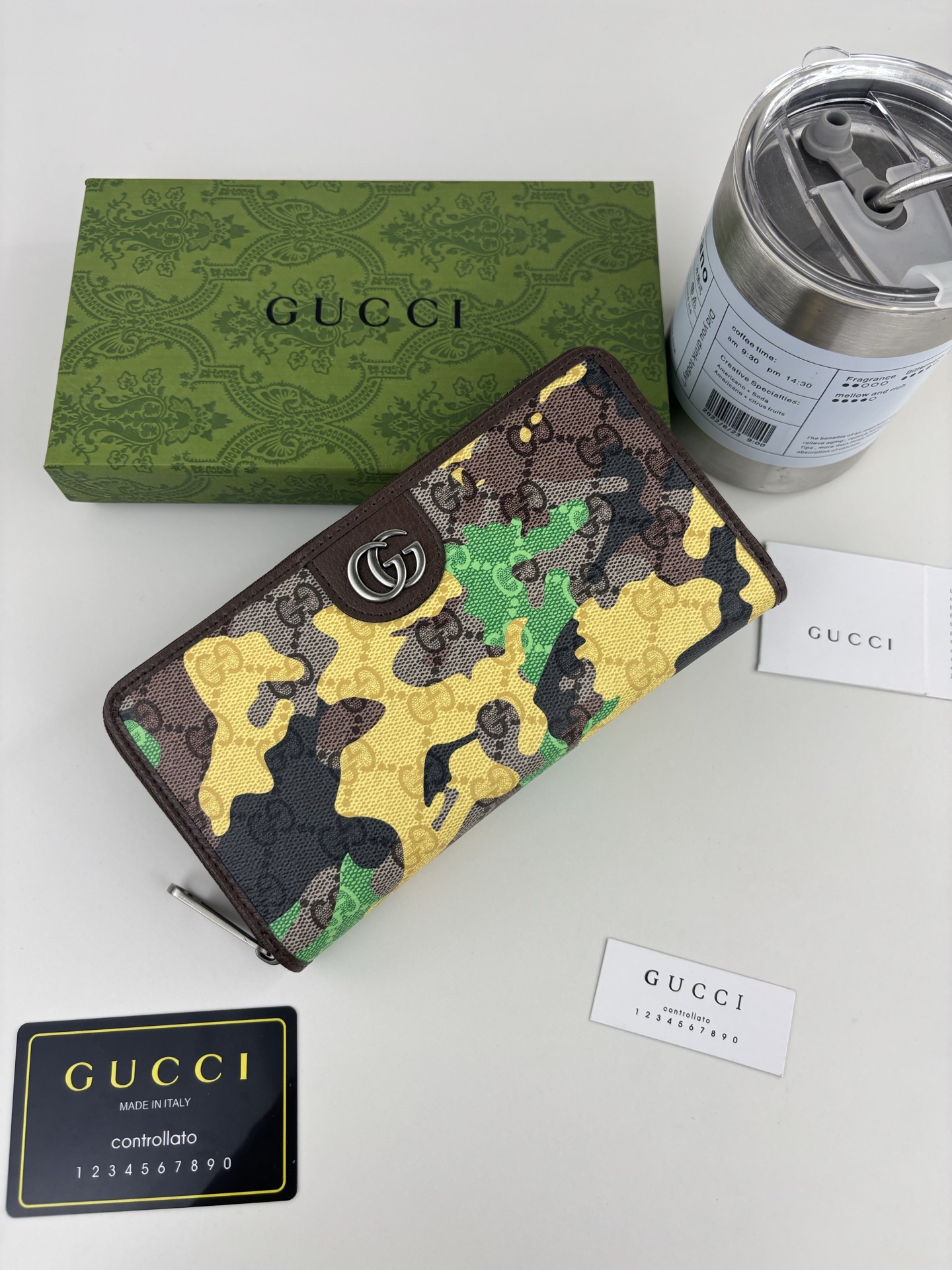 GUCCl生动迷彩结合别致配色，焕新演绎经典GG图案。这款全拉链钱包以大理石纹GG字母图案涂层织物打造，匠心融蕴双G细节