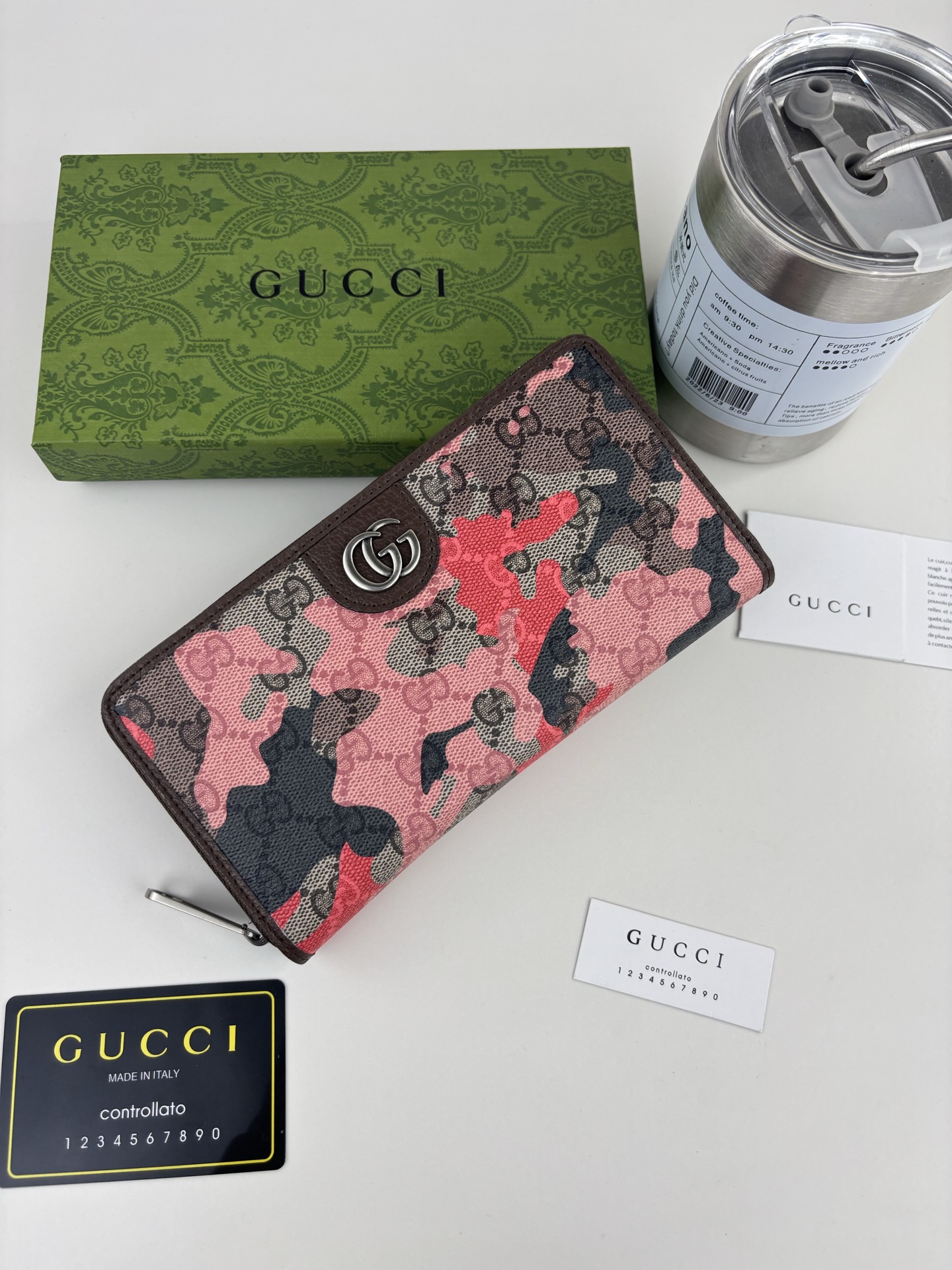 GUCCl生动迷彩结合别致配色，焕新演绎经典GG图案。这款全拉链钱包以大理石纹GG字母图案涂层织物打造，匠心融蕴双G细节