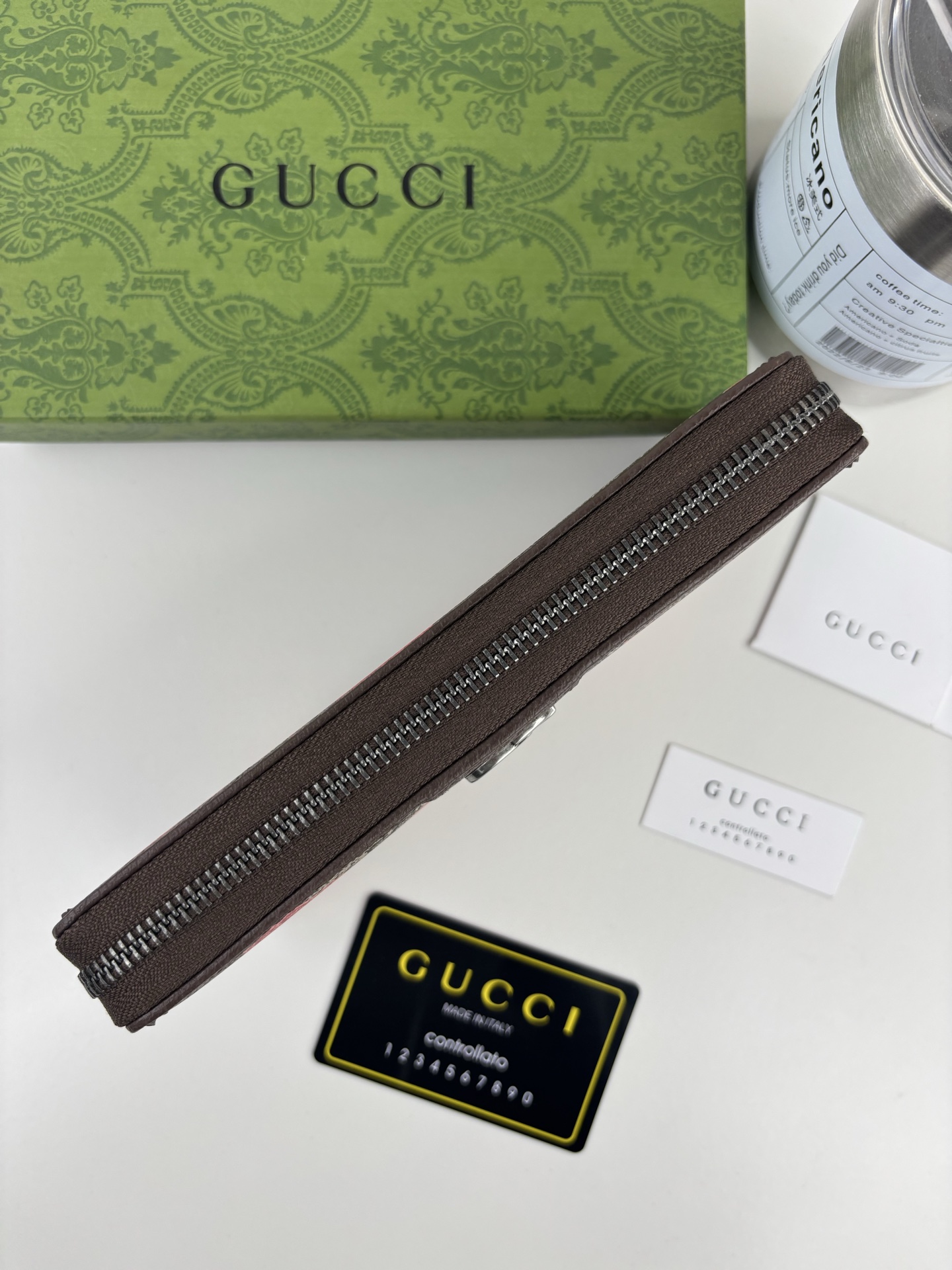 GUCCl生动迷彩结合别致配色，焕新演绎经典GG图案。这款全拉链钱包以大理石纹GG字母图案涂层织物打造，匠心融蕴双G细节