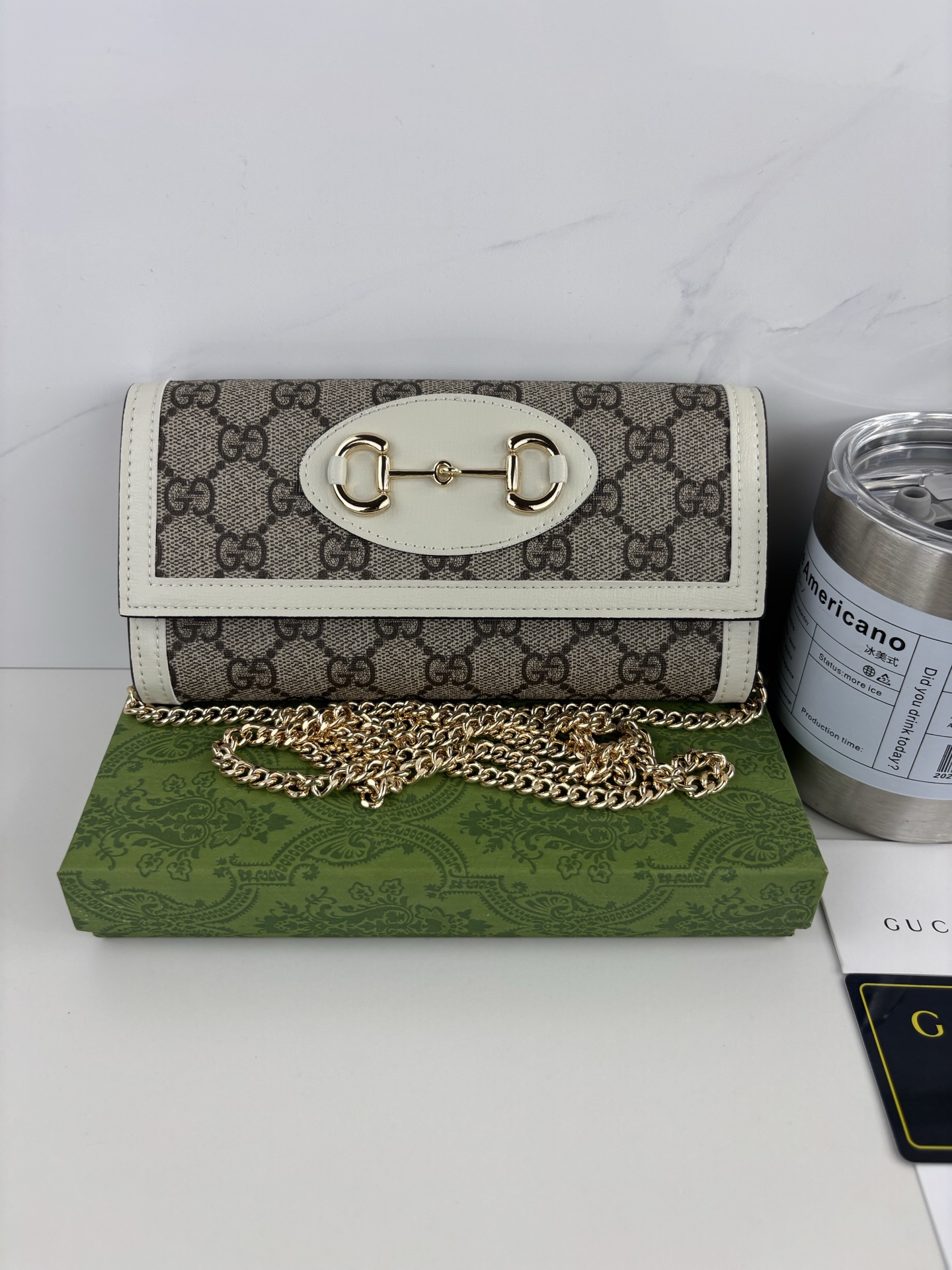 GUCCl 全新推出这款由GG Supreme高级人造帆布和白色皮革材质制成的Gucci,1955马衔扣卡包该系列采用与 GUCCl 全新推出这款由GG Supreme高级人造帆布和白色皮革材质制成的Gucci,1955马衔扣卡包该系列采用与