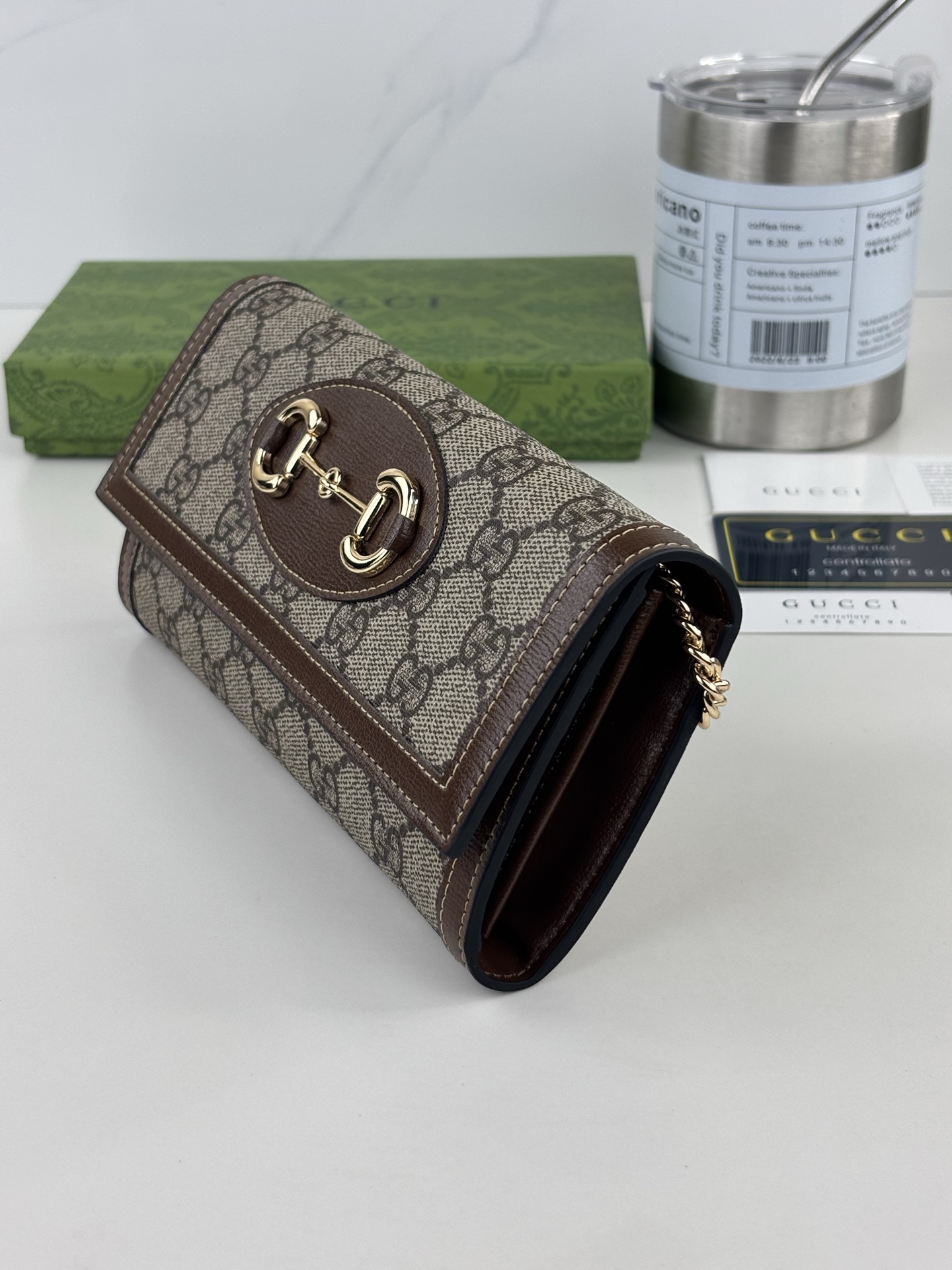GUCCl 全新推出这款由GG Supreme高级人造帆布和白色皮革材质制成的Gucci，1955马衔扣卡包该系列采用与