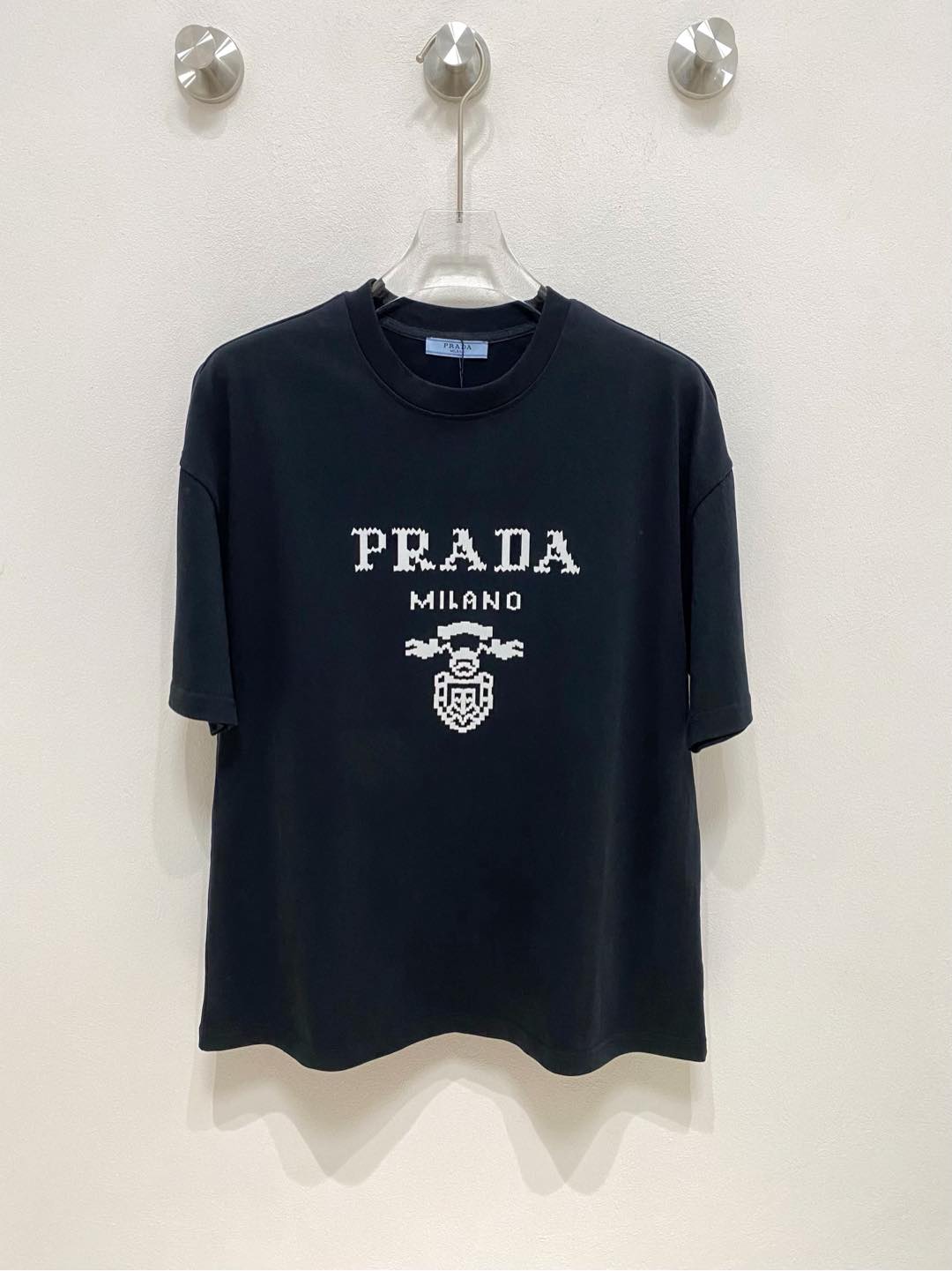 ZS\n Prada 普拉达 SS春夏新品 \n\n重磅级尤物单品，官网在售系列。浮雕短袖T恤，定织微融感高支纯棉面料，手感非常好，前幅浮雕标识印花图案装饰，增加立体感，层次清晰丰富立体，做工一流， os落肩宽松版型，简约易搭配，男女同款，\n\n尺码S-XL\n男女同款\n两色推荐 黑色 白色\n