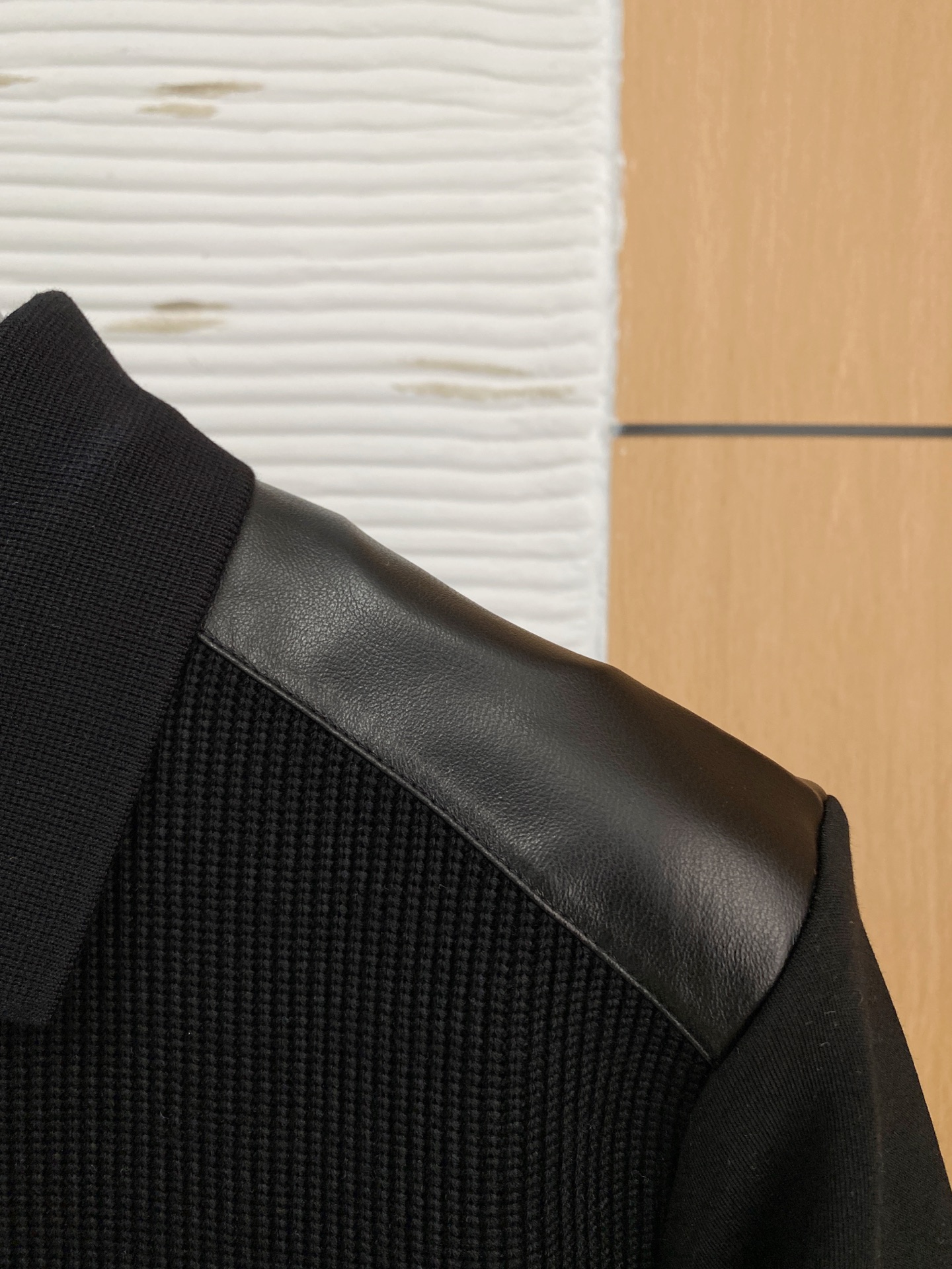 。普拉达 2025秋冬  羊毛混纺套头针织卫衣  几何拼皮的口袋设计 很有亮点，标志字母纽扣 细节上凸显