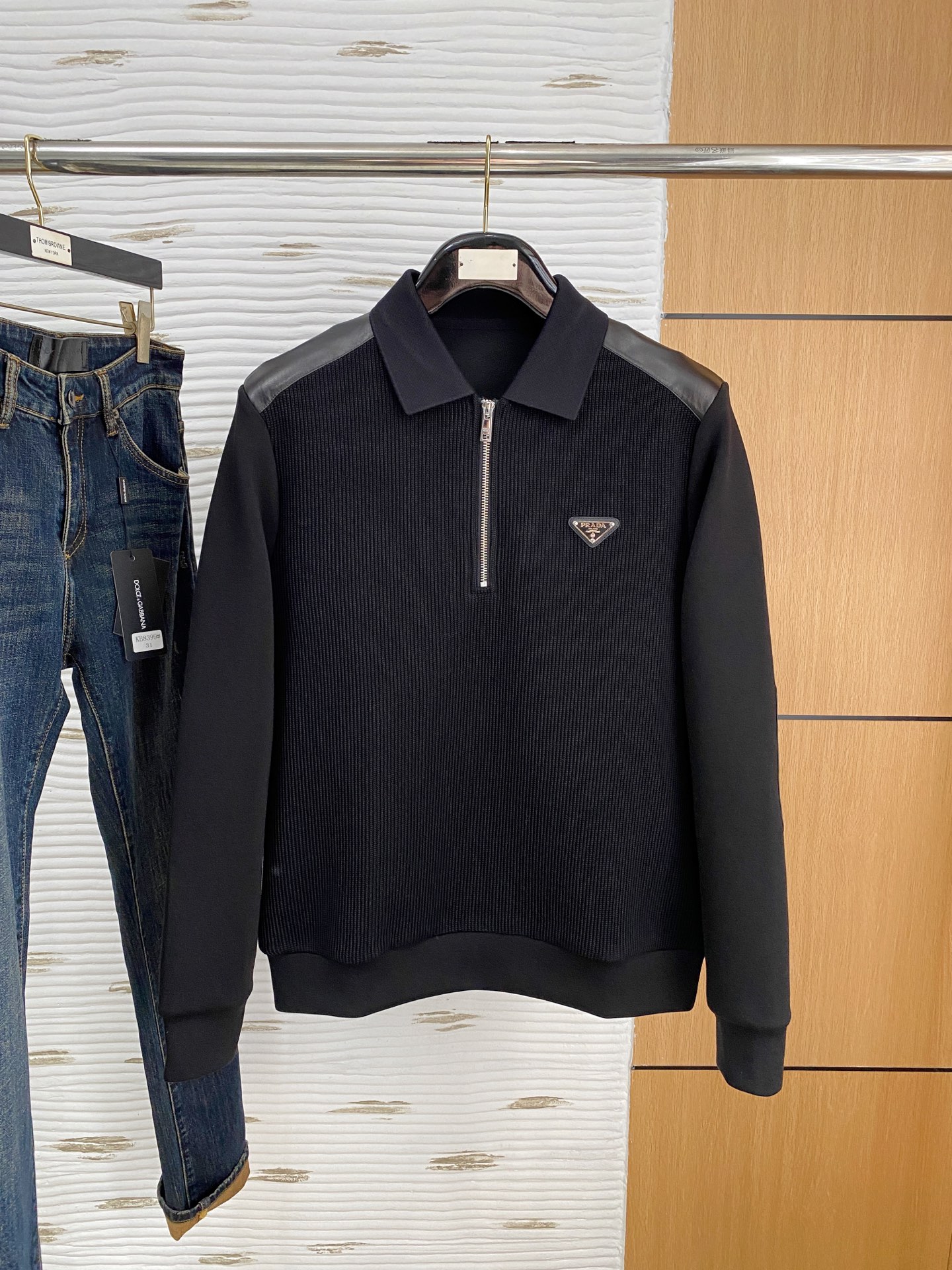 。普拉达 2025秋冬  羊毛混纺套头针织卫衣  几何拼皮的口袋设计 很有亮点，标志字母纽扣 细节上凸显