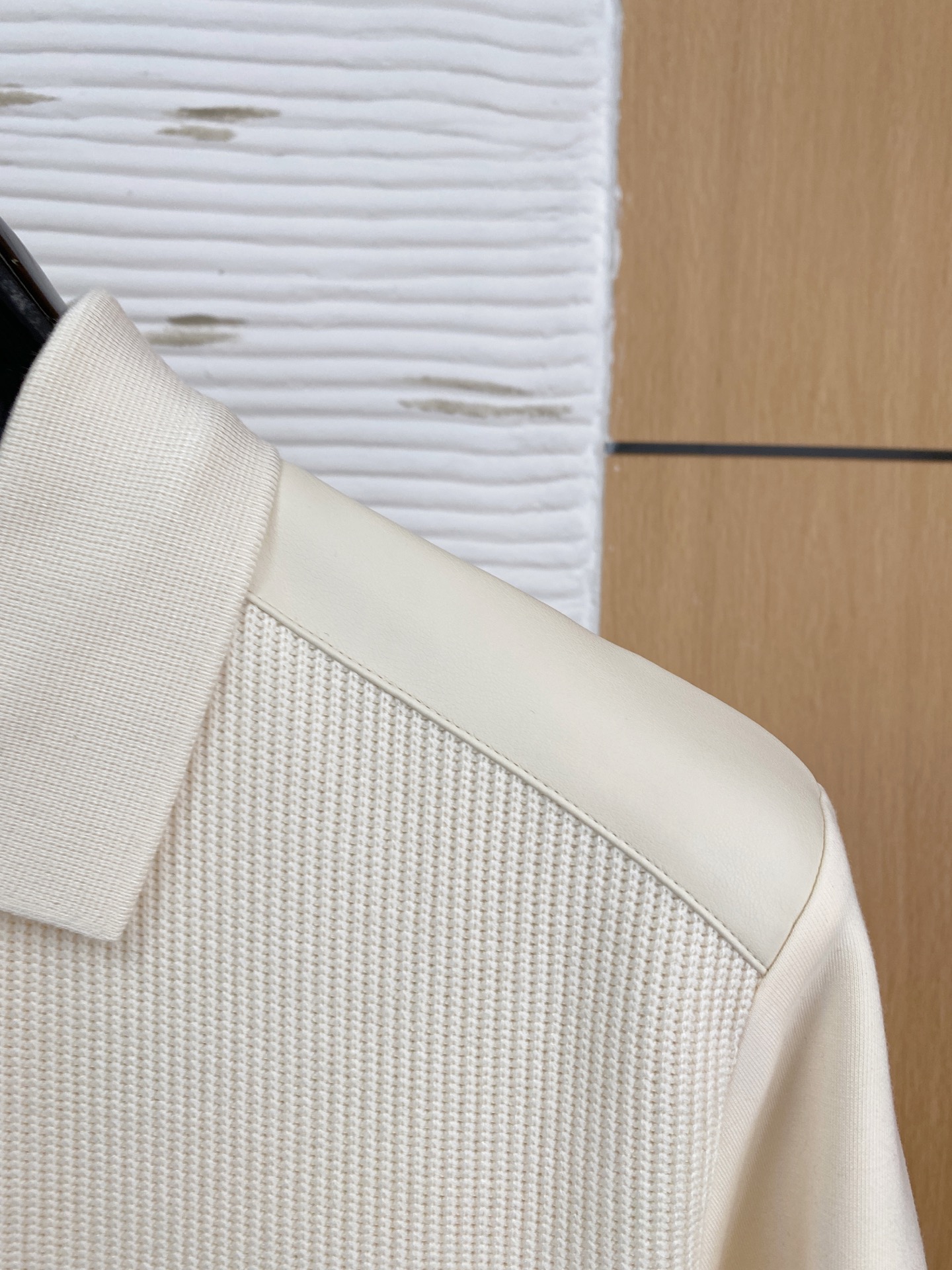 。普拉达 2025秋冬  羊毛混纺套头针织卫衣  几何拼皮的口袋设计 很有亮点，标志字母纽扣 细节上凸显