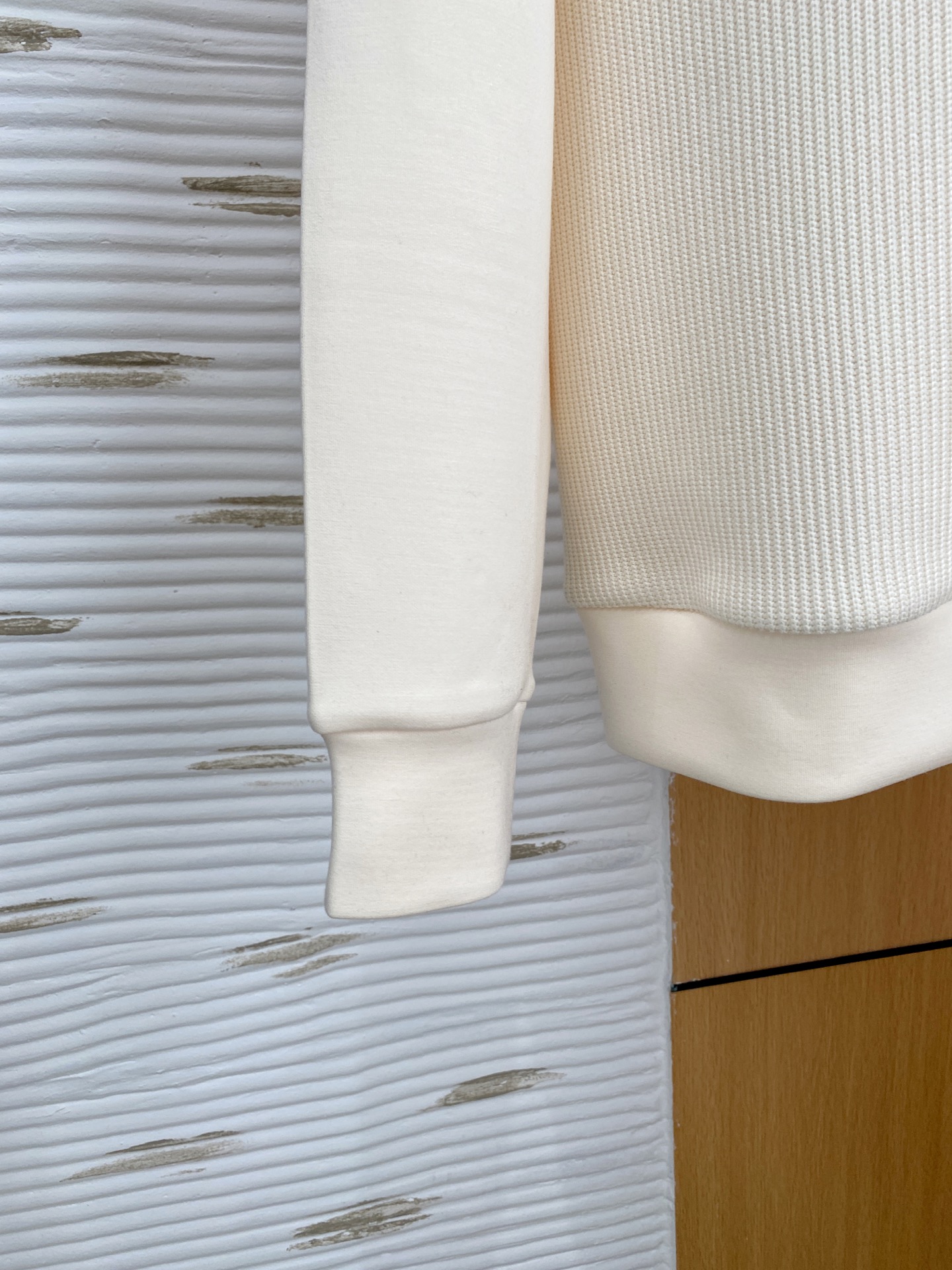 。普拉达 2025秋冬  羊毛混纺套头针织卫衣  几何拼皮的口袋设计 很有亮点，标志字母纽扣 细节上凸显