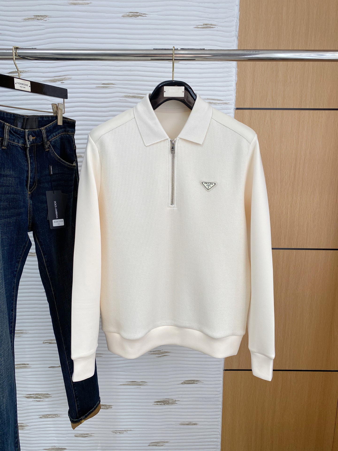 。普拉达 2025秋冬  羊毛混纺套头针织卫衣  几何拼皮的口袋设计 很有亮点，标志字母纽扣 细节上凸显