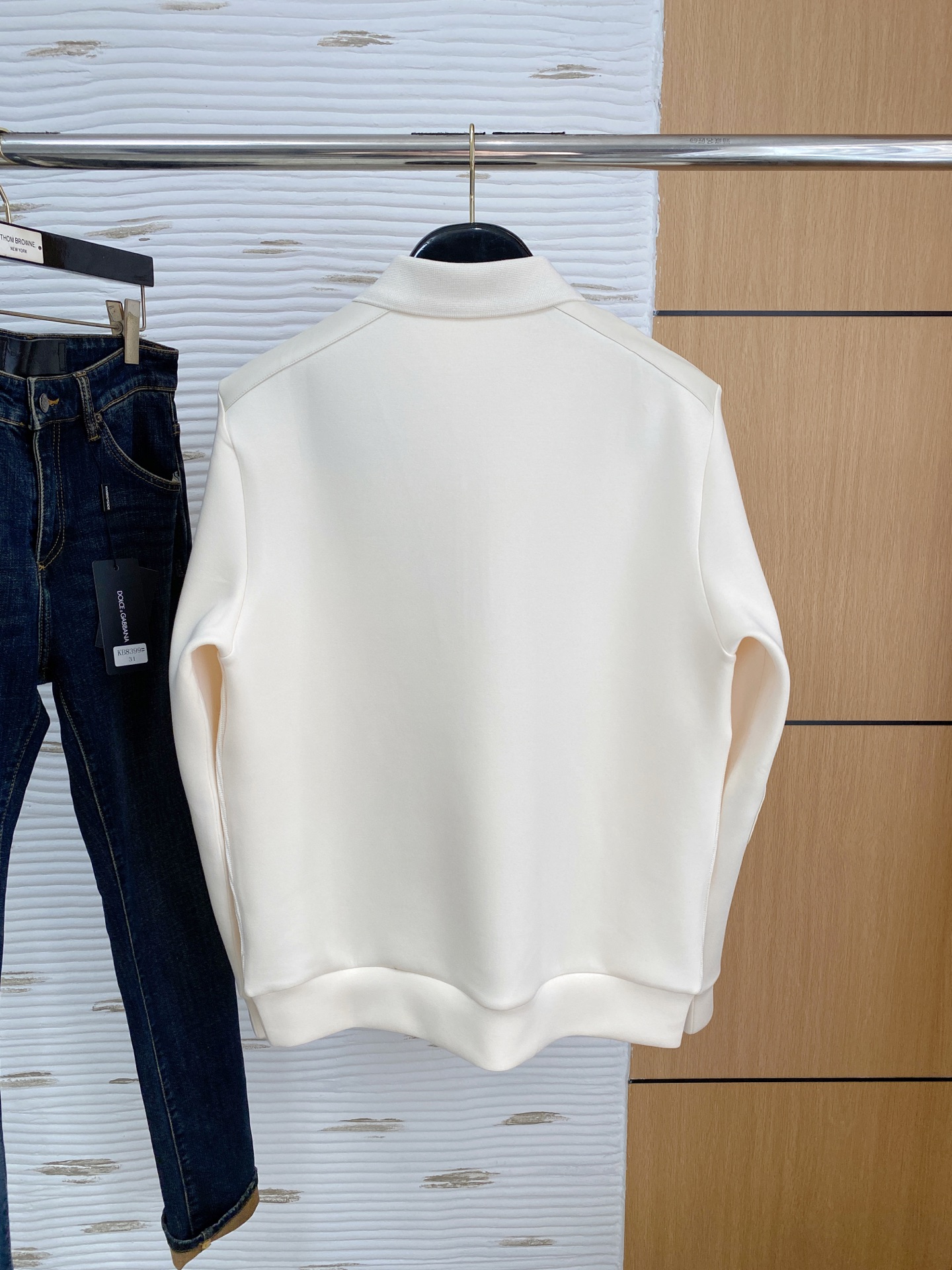 。普拉达 2025秋冬  羊毛混纺套头针织卫衣  几何拼皮的口袋设计 很有亮点，标志字母纽扣 细节上凸显