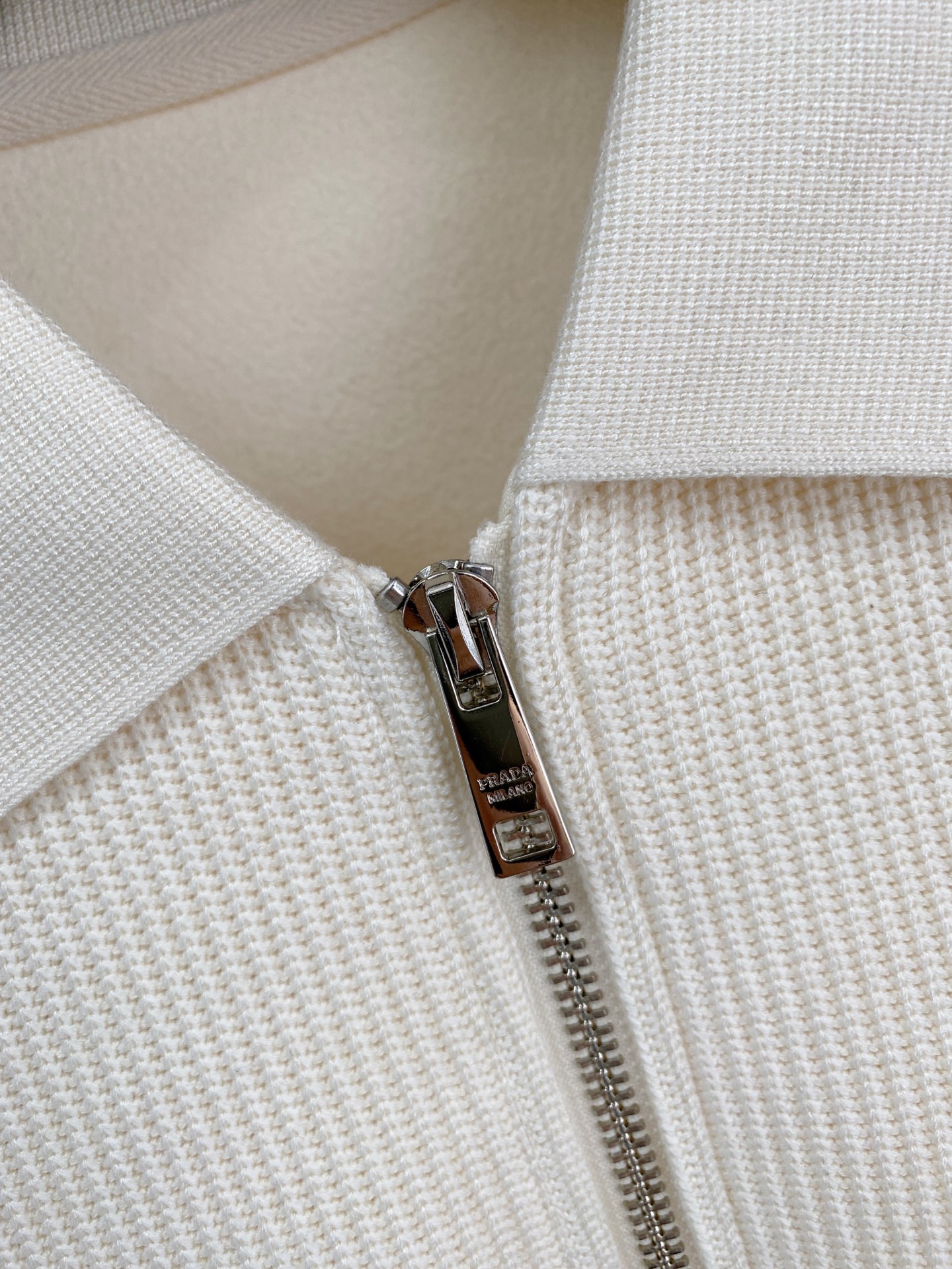 。普拉达 2025秋冬  羊毛混纺套头针织卫衣  几何拼皮的口袋设计 很有亮点，标志字母纽扣 细节上凸显