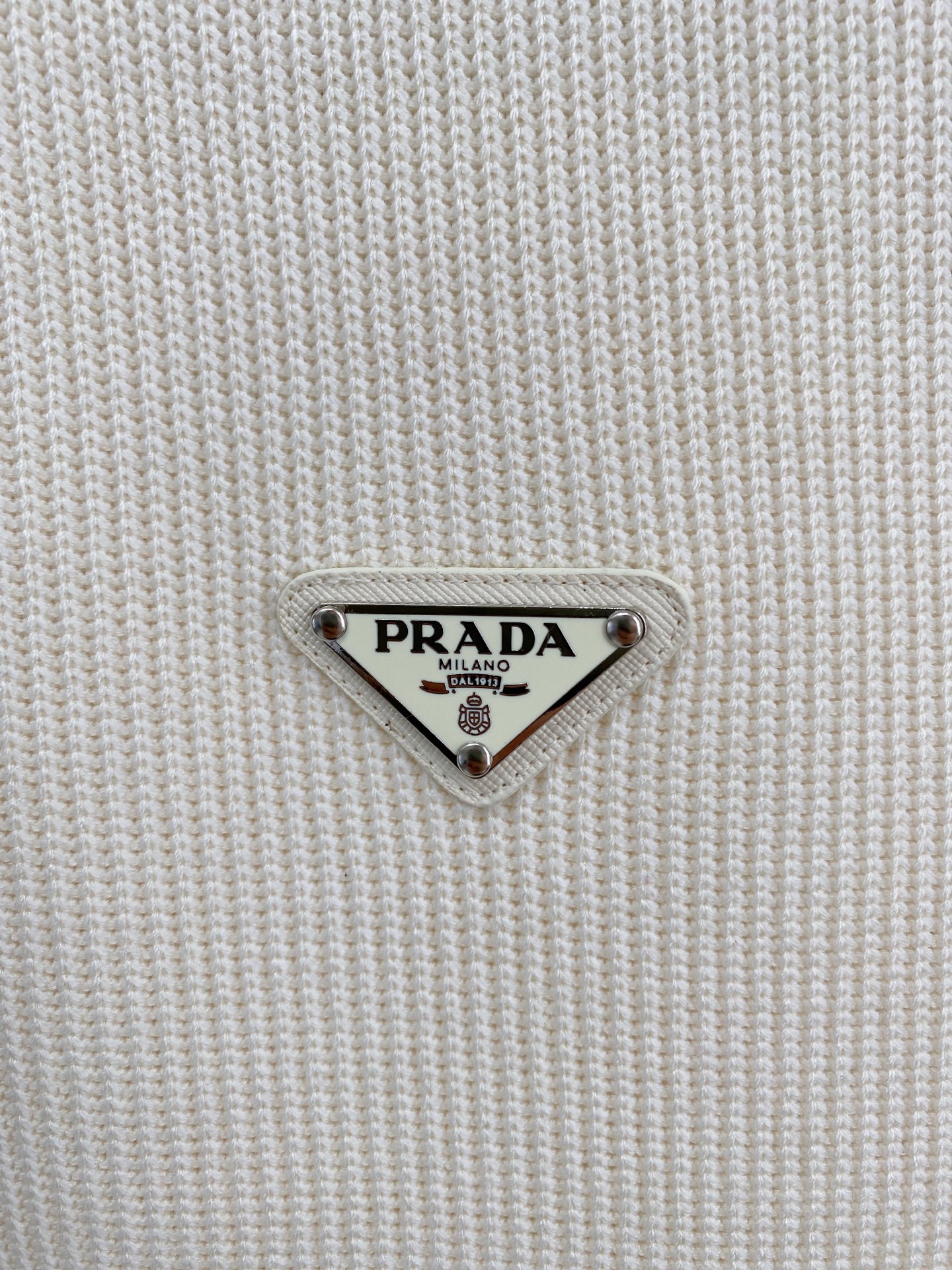 。普拉达 2025秋冬  羊毛混纺套头针织卫衣  几何拼皮的口袋设计 很有亮点，标志字母纽扣 细节上凸显