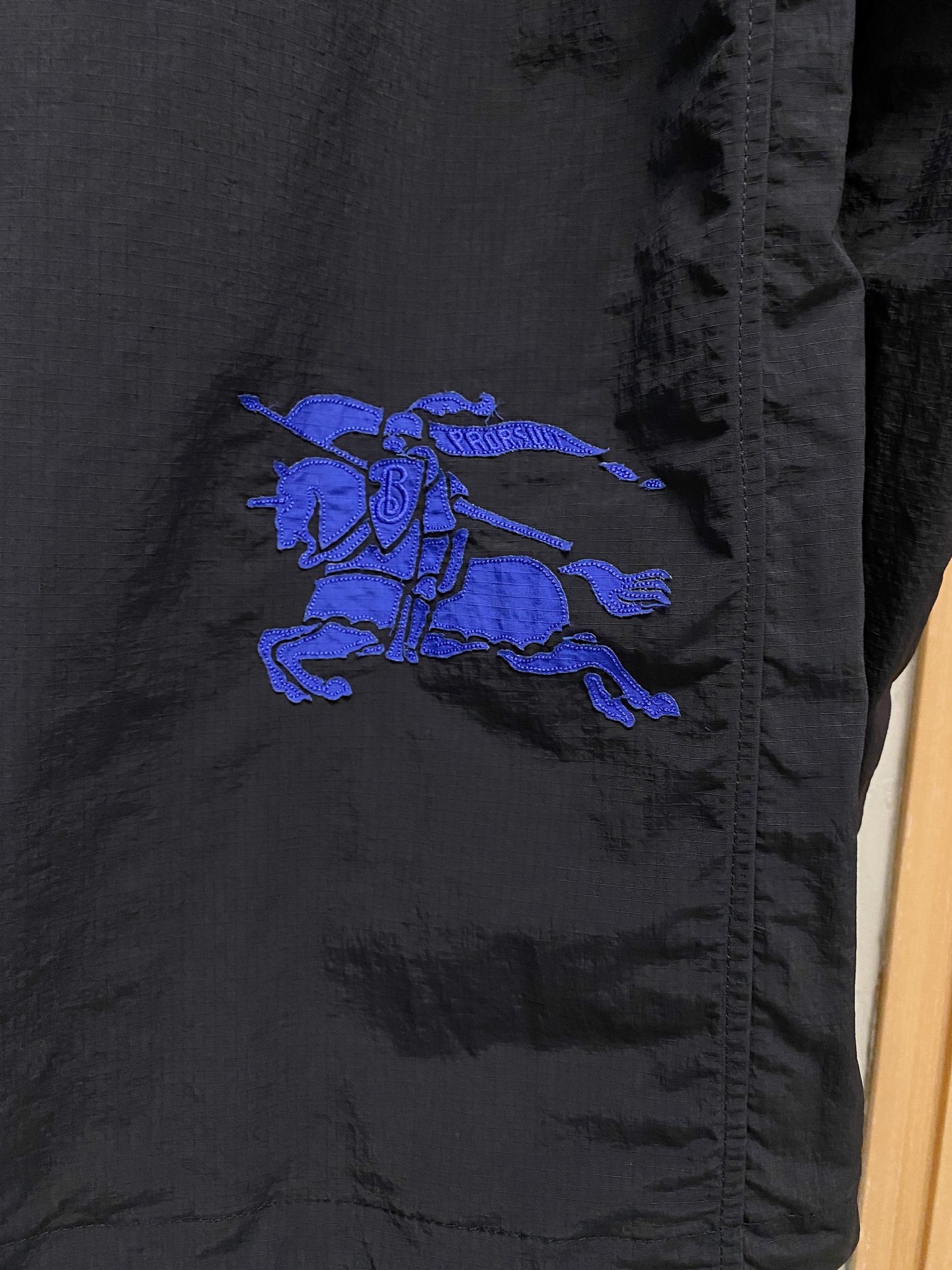 连帽外套，选用轻盈尼龙面料打造。背部点缀马术骑士徽标（EKD）刺绣，呈现休闲版型 整体较常规版型剪裁更为