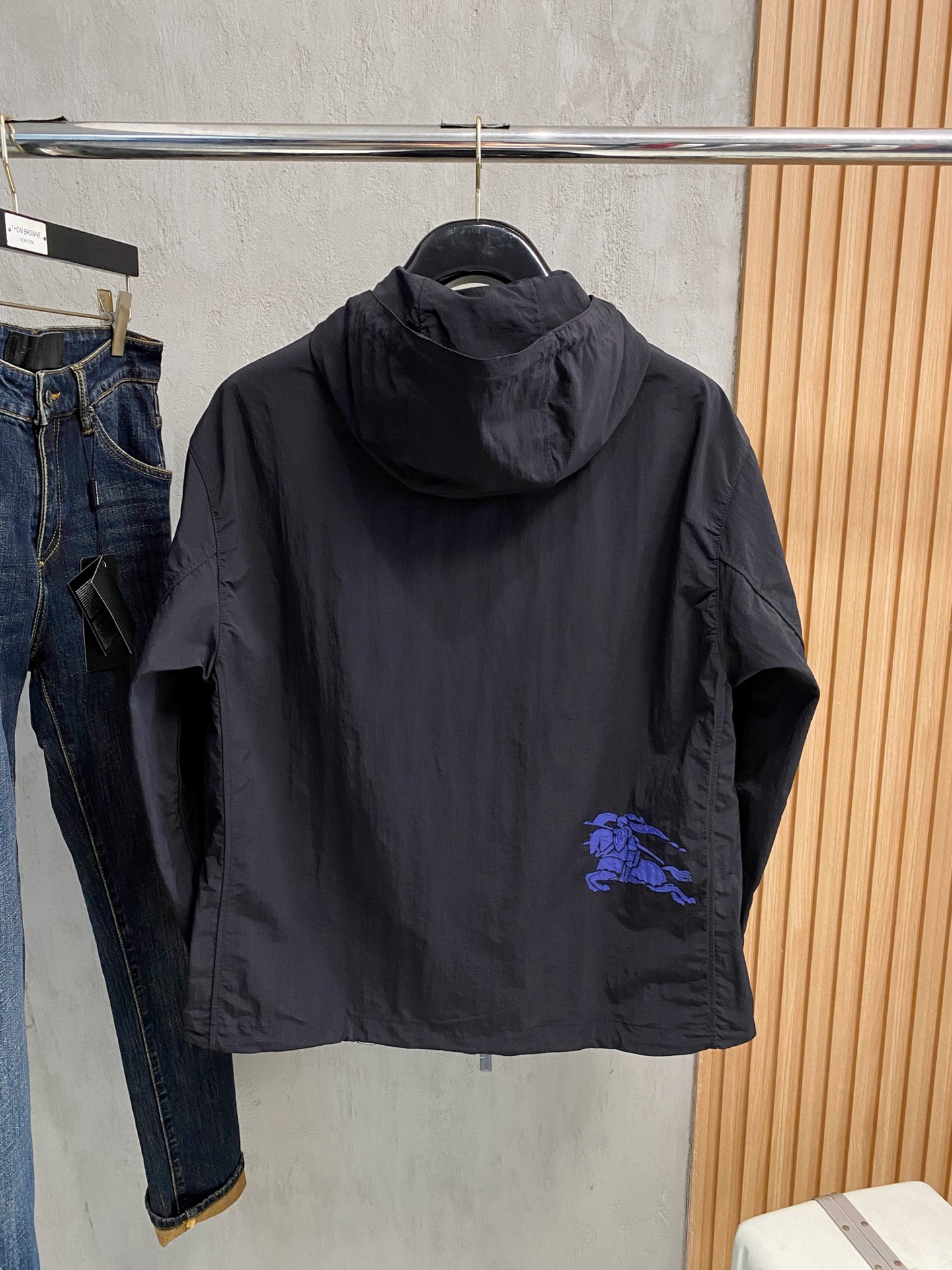 连帽外套，选用轻盈尼龙面料打造。背部点缀马术骑士徽标（EKD）刺绣，呈现休闲版型 整体较常规版型剪裁更为