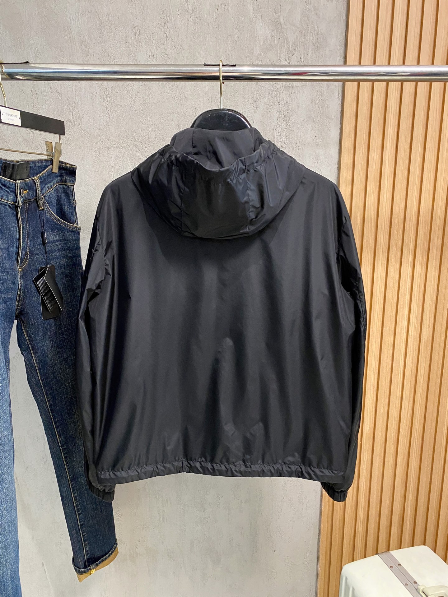 兜帽和侧边拉链口袋风衣。松紧袖口和抽绳下摆。双头拉链开合。蓝色尼龙材质。胸前拉链袋饰有相搭的“Made 