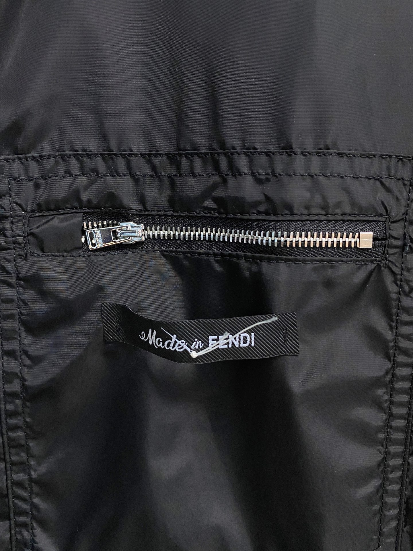 兜帽和侧边拉链口袋风衣。松紧袖口和抽绳下摆。双头拉链开合。蓝色尼龙材质。胸前拉链袋饰有相搭的“Made 