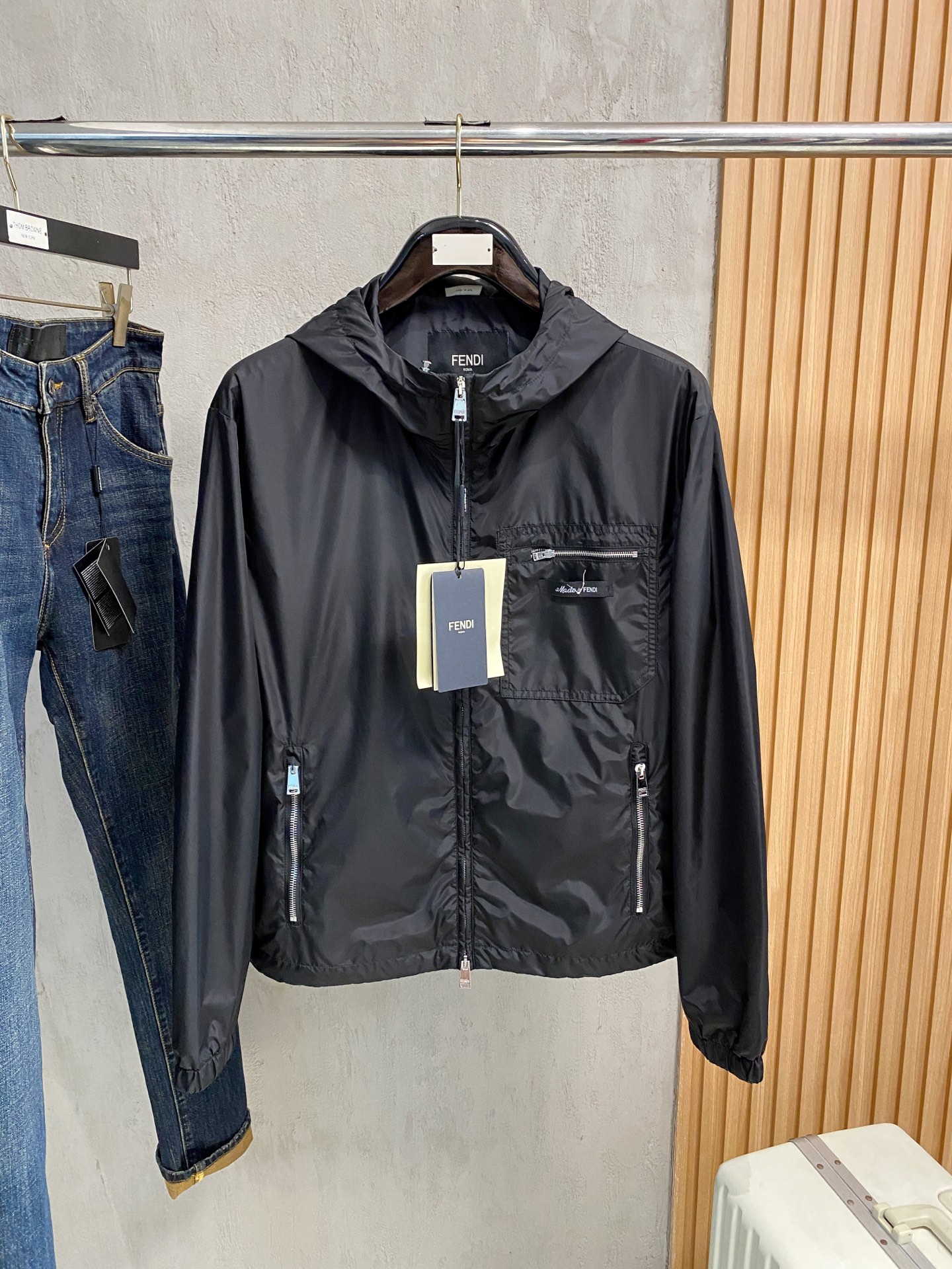 兜帽和侧边拉链口袋风衣。松紧袖口和抽绳下摆。双头拉链开合。蓝色尼龙材质。胸前拉链袋饰有相搭的“Made 