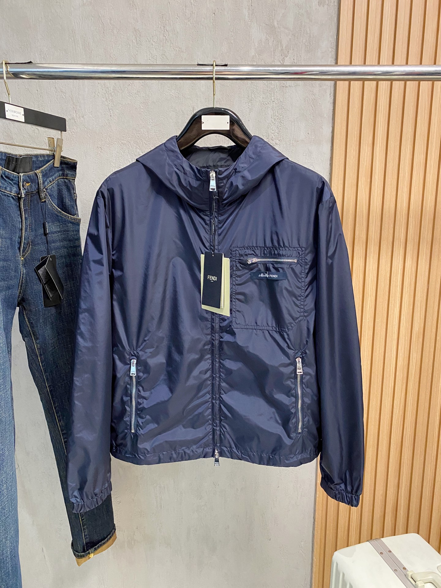 兜帽和侧边拉链口袋风衣。松紧袖口和抽绳下摆。双头拉链开合。蓝色尼龙材质。胸前拉链袋饰有相搭的“Made 