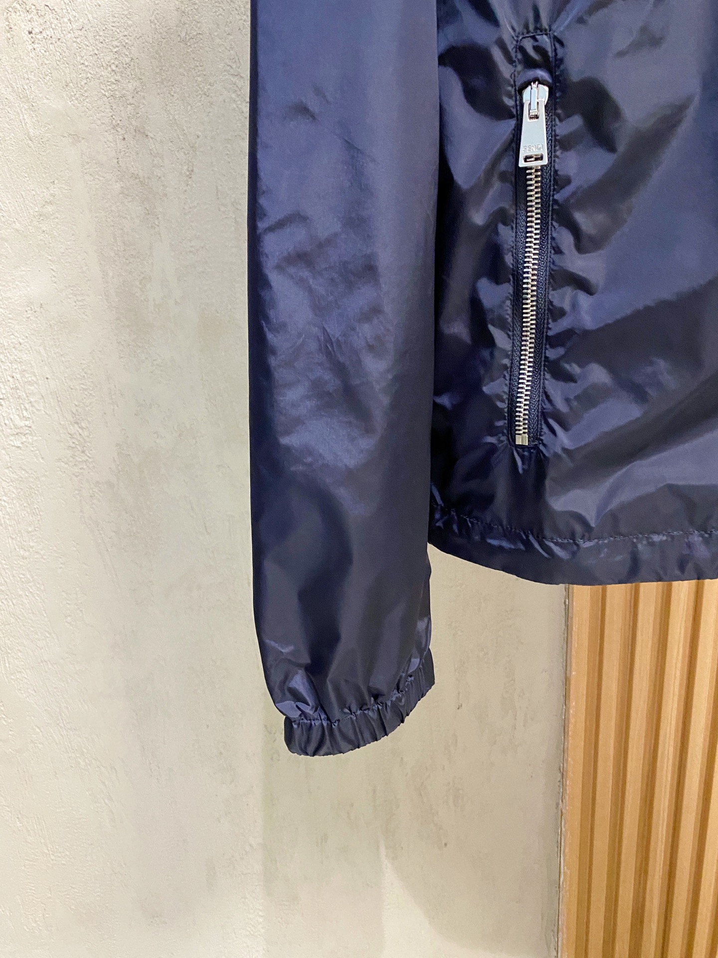 兜帽和侧边拉链口袋风衣。松紧袖口和抽绳下摆。双头拉链开合。蓝色尼龙材质。胸前拉链袋饰有相搭的“Made 