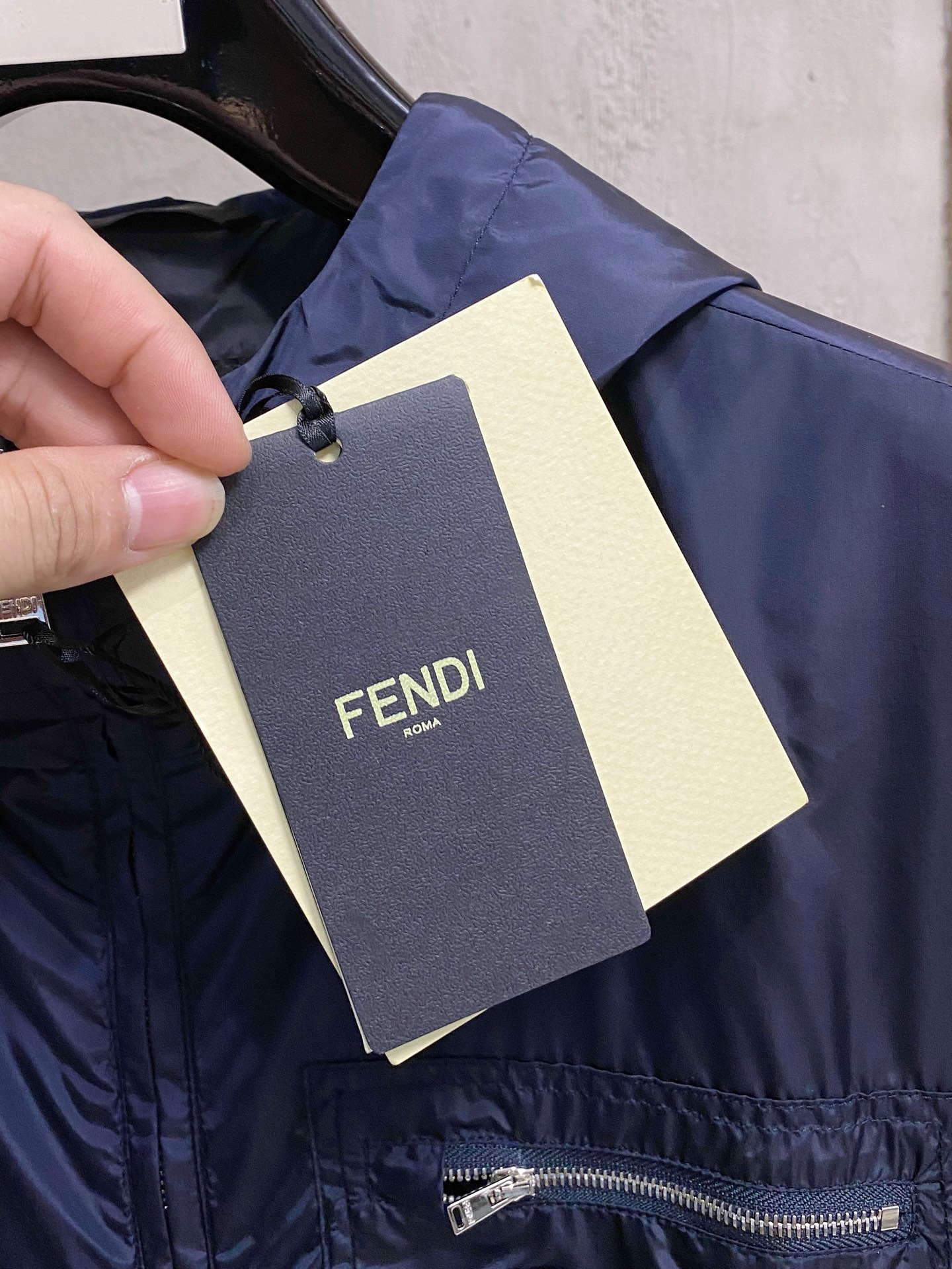 兜帽和侧边拉链口袋风衣。松紧袖口和抽绳下摆。双头拉链开合。蓝色尼龙材质。胸前拉链袋饰有相搭的“Made 