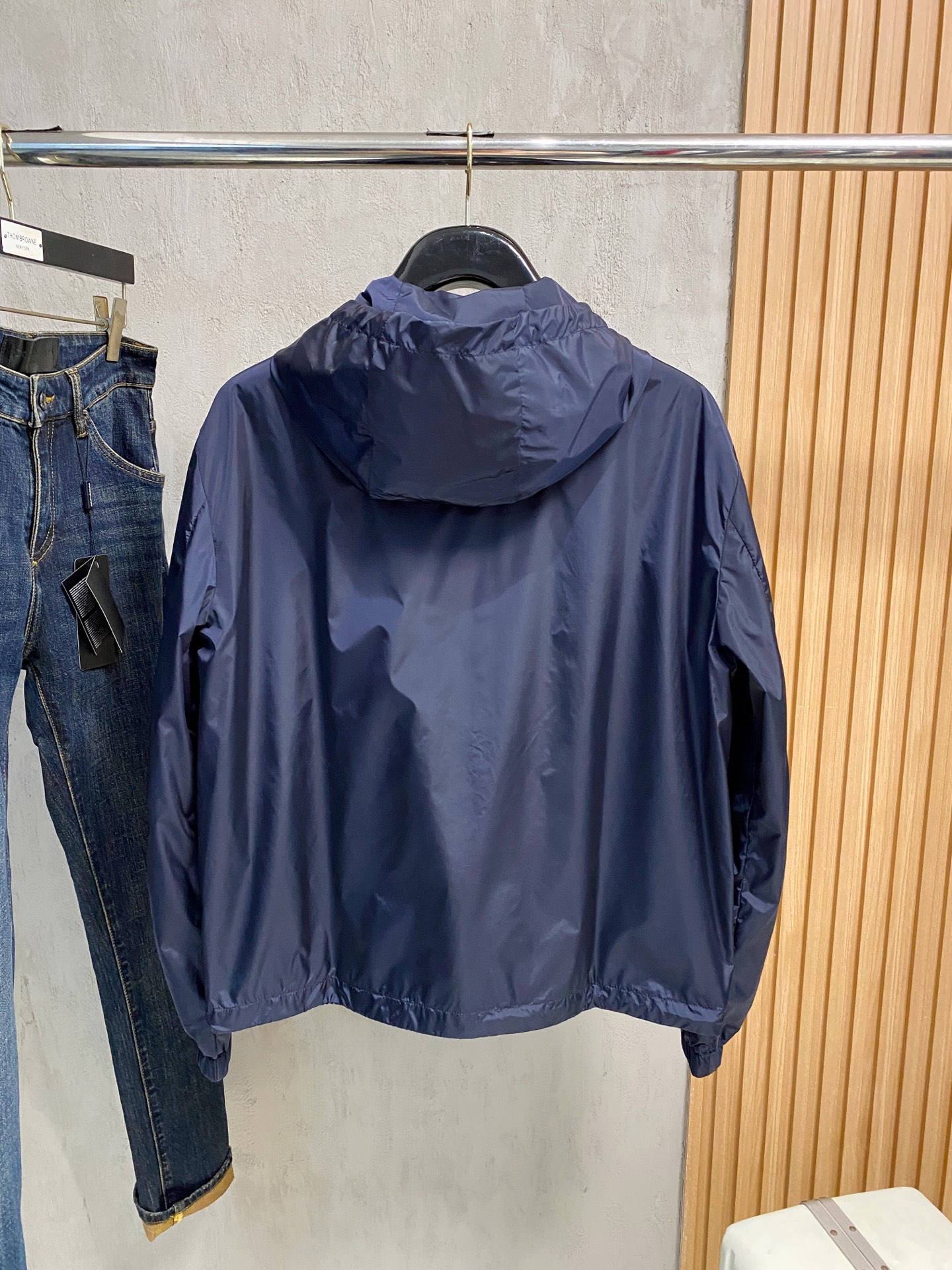 兜帽和侧边拉链口袋风衣。松紧袖口和抽绳下摆。双头拉链开合。蓝色尼龙材质。胸前拉链袋饰有相搭的“Made 