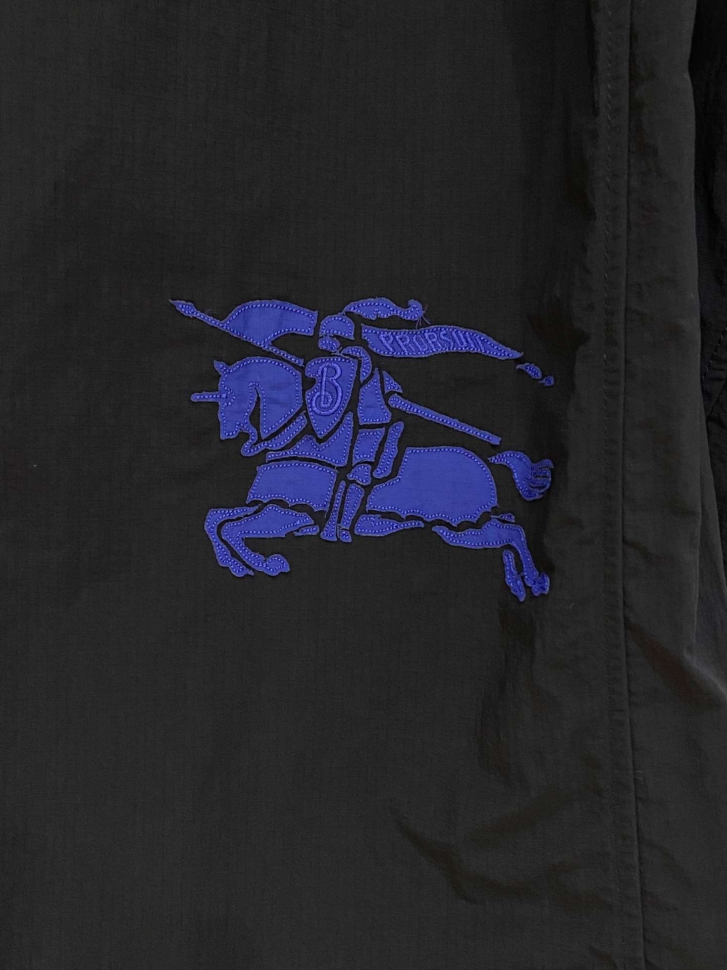 连帽外套，选用轻盈尼龙面料打造。背部点缀马术骑士徽标（EKD）刺绣，呈现休闲版型 整体较常规版型剪裁更为