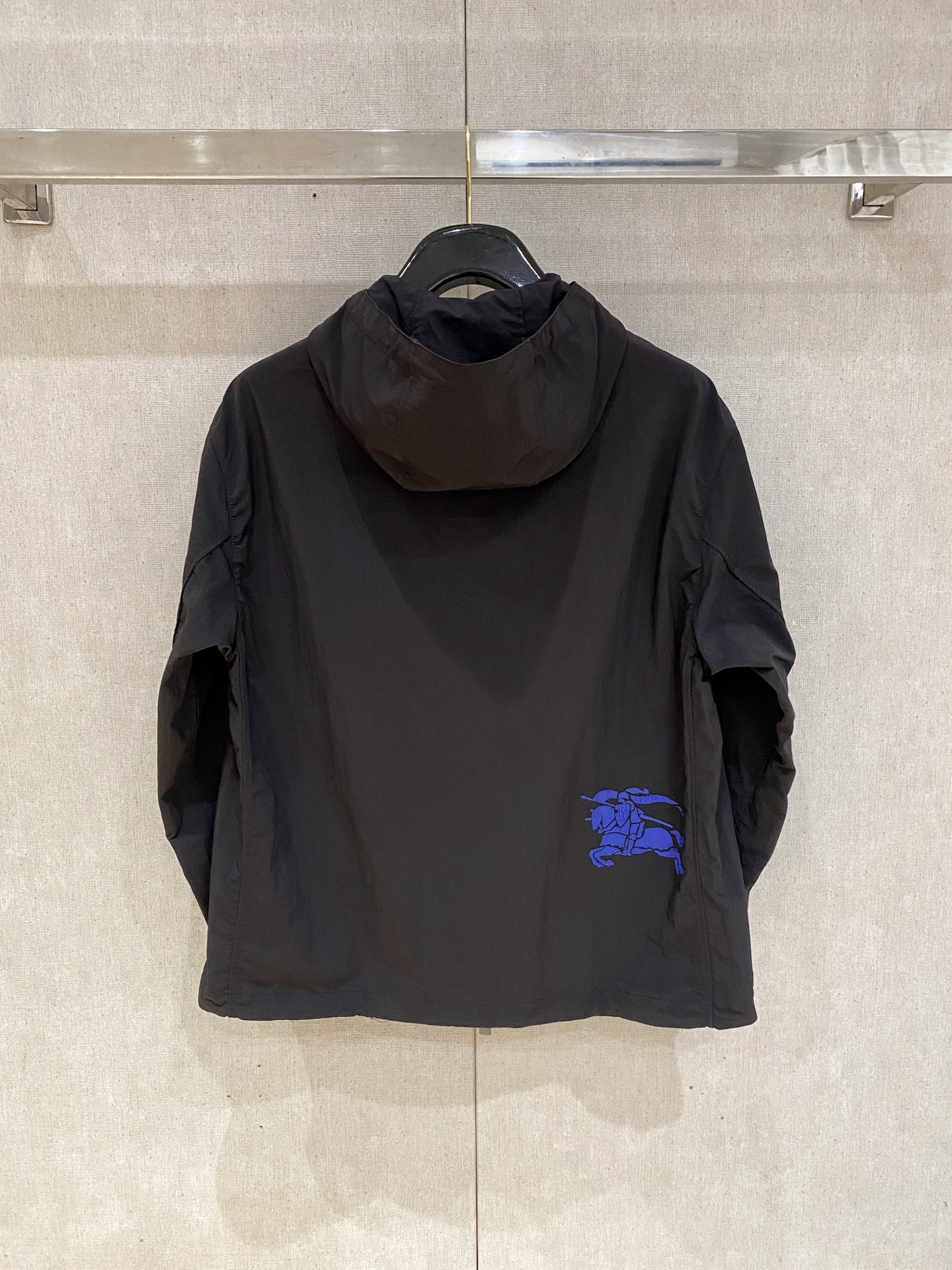 连帽外套，选用轻盈尼龙面料打造。背部点缀马术骑士徽标（EKD）刺绣，呈现休闲版型 整体较常规版型剪裁更为