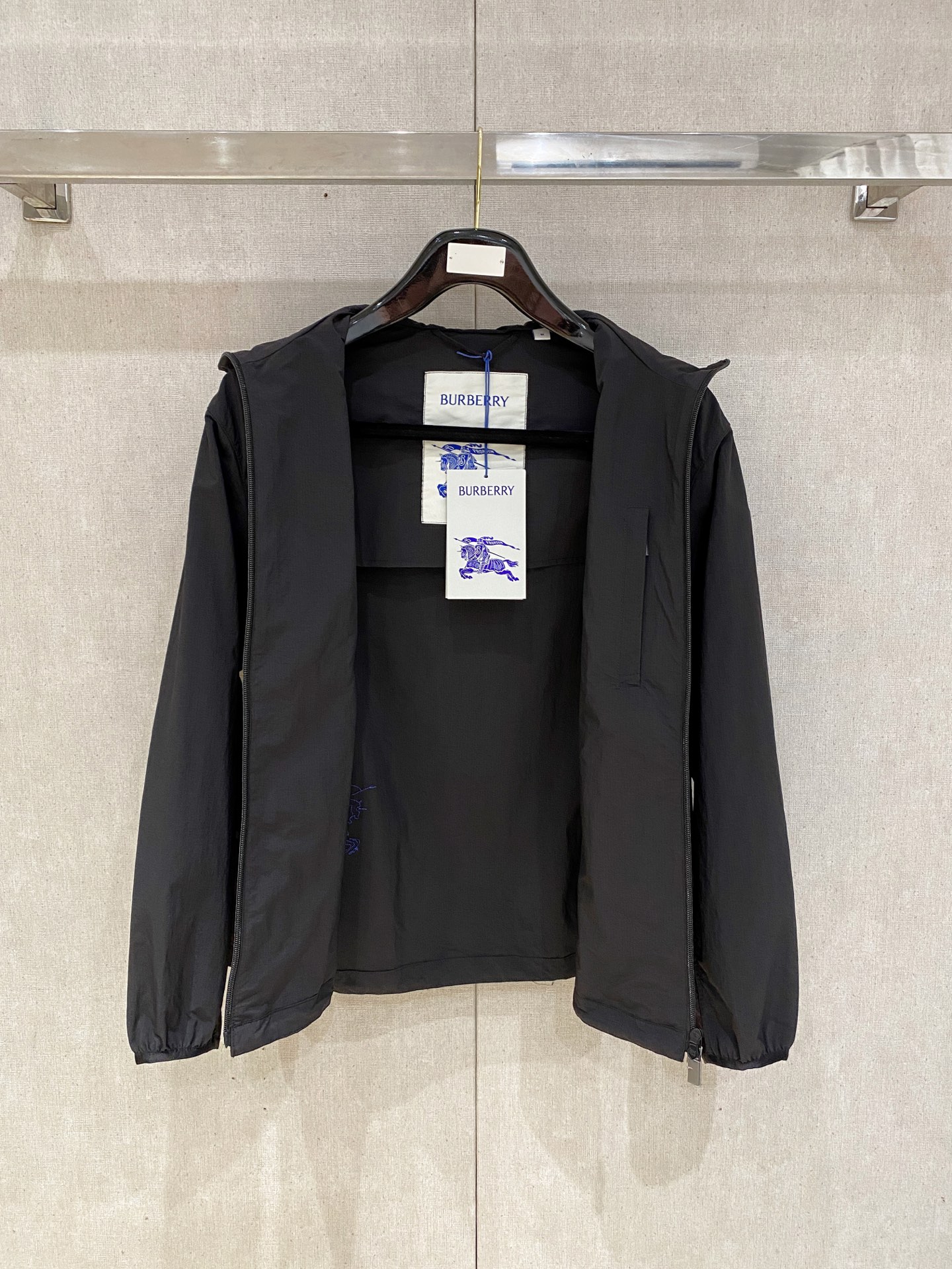 连帽外套，选用轻盈尼龙面料打造。背部点缀马术骑士徽标（EKD）刺绣，呈现休闲版型 整体较常规版型剪裁更为