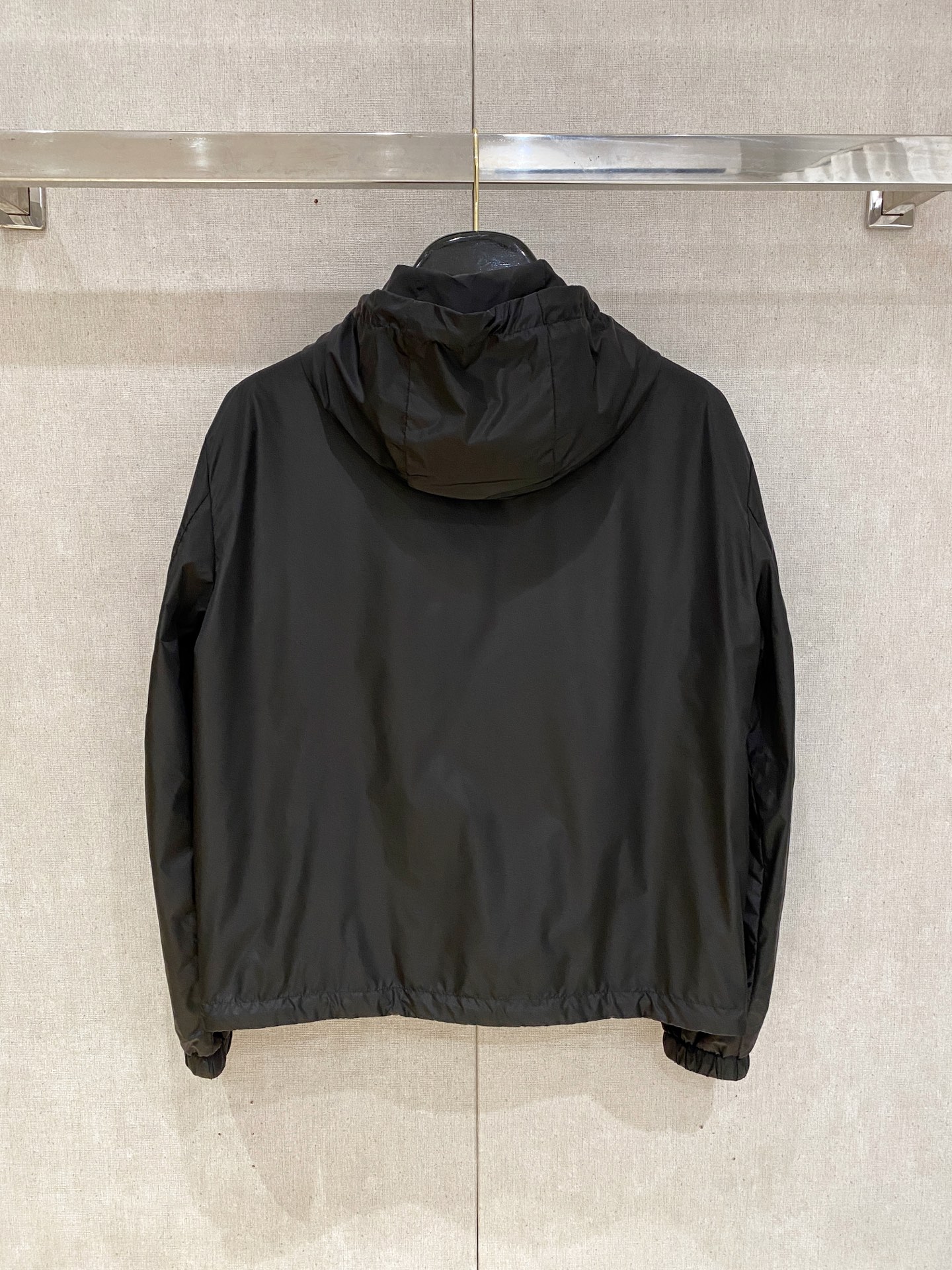 兜帽和侧边拉链口袋风衣。松紧袖口和抽绳下摆。双头拉链开合。蓝色尼龙材质。胸前拉链袋饰有相搭的“Made 