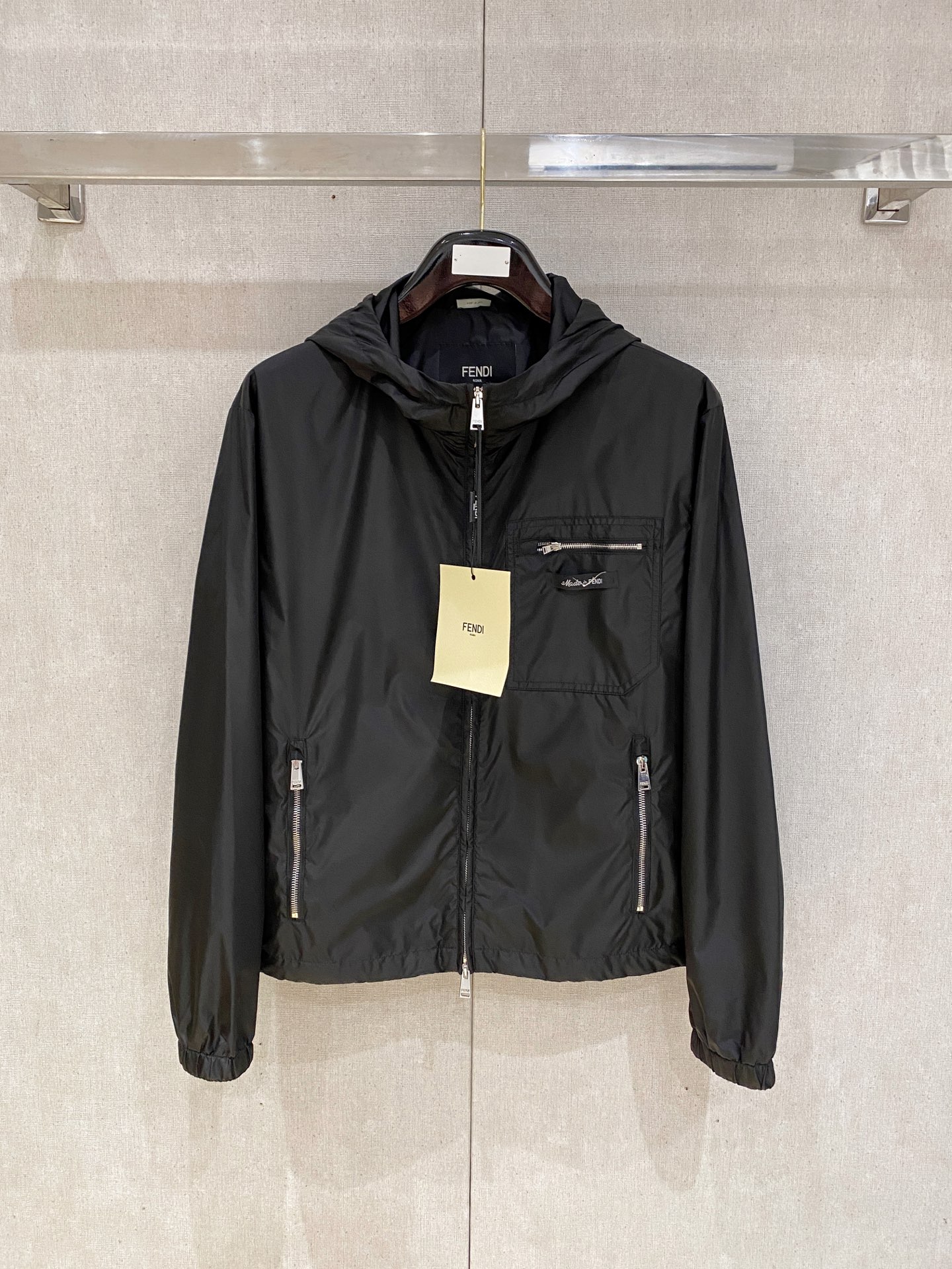 兜帽和侧边拉链口袋风衣。松紧袖口和抽绳下摆。双头拉链开合。蓝色尼龙材质。胸前拉链袋饰有相搭的“Made 