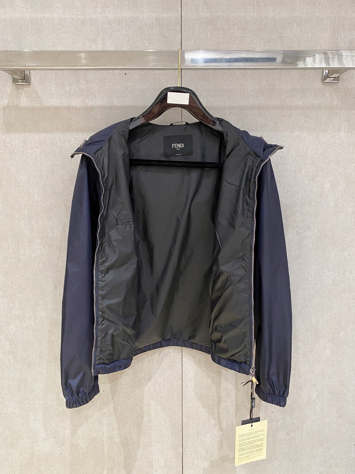 兜帽和侧边拉链口袋风衣。松紧袖口和抽绳下摆。双头拉链开合。蓝色尼龙材质。胸前拉链袋饰有相搭的“Made 