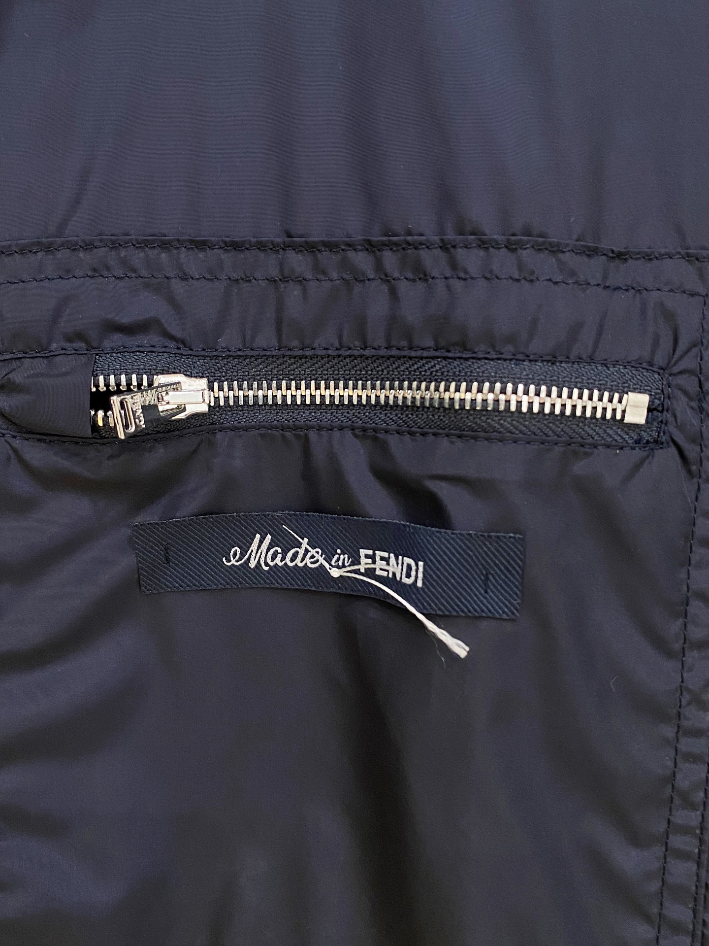 兜帽和侧边拉链口袋风衣。松紧袖口和抽绳下摆。双头拉链开合。蓝色尼龙材质。胸前拉链袋饰有相搭的“Made 