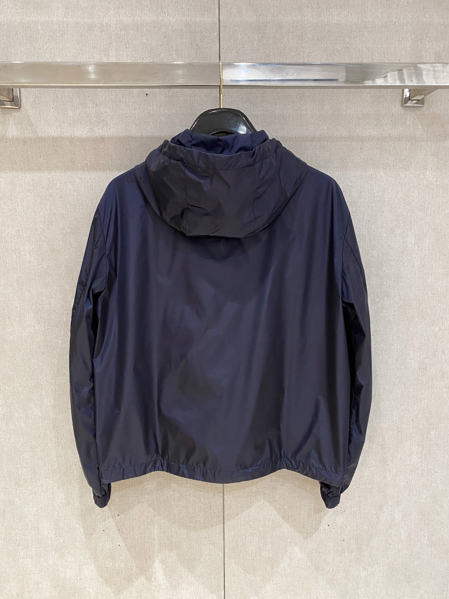 兜帽和侧边拉链口袋风衣。松紧袖口和抽绳下摆。双头拉链开合。蓝色尼龙材质。胸前拉链袋饰有相搭的“Made 