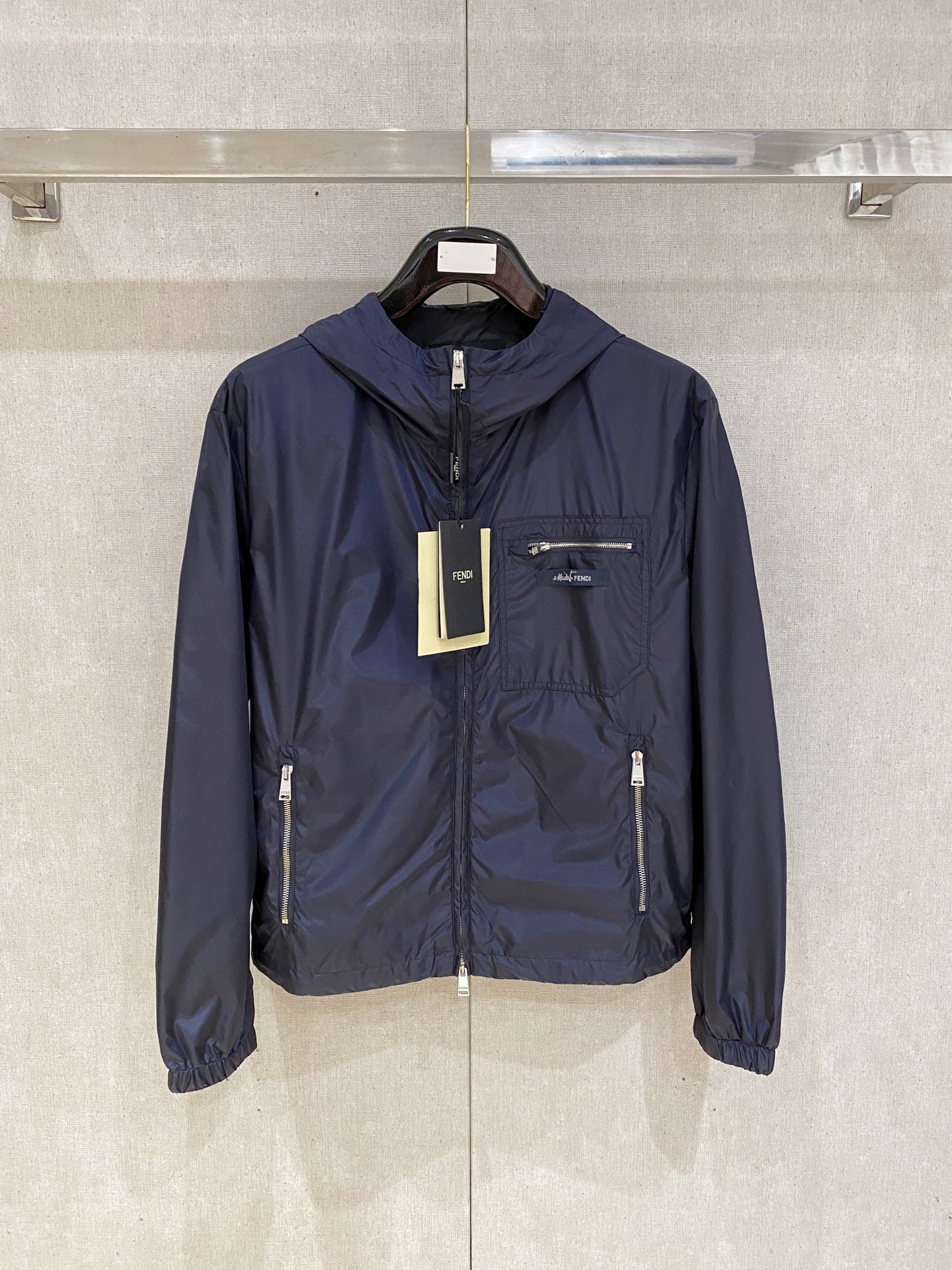 兜帽和侧边拉链口袋风衣。松紧袖口和抽绳下摆。双头拉链开合。蓝色尼龙材质。胸前拉链袋饰有相搭的“Made 