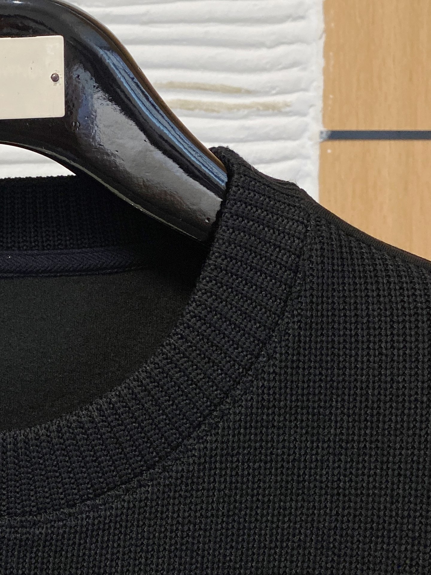 。普拉达 2025秋冬  羊毛混纺套头针织卫衣  几何拼皮的口袋设计 很有亮点，标志字母纽扣 细节上凸显