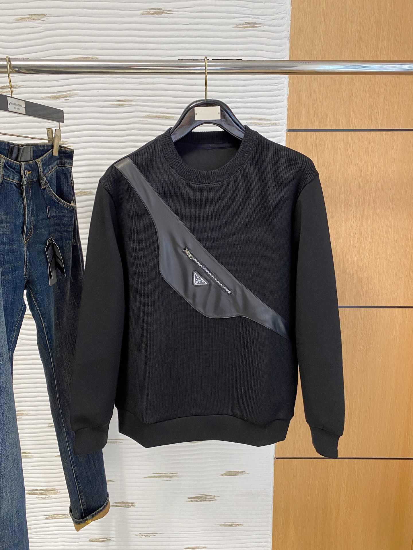 。普拉达 2025秋冬  羊毛混纺套头针织卫衣  几何拼皮的口袋设计 很有亮点，标志字母纽扣 细节上凸显