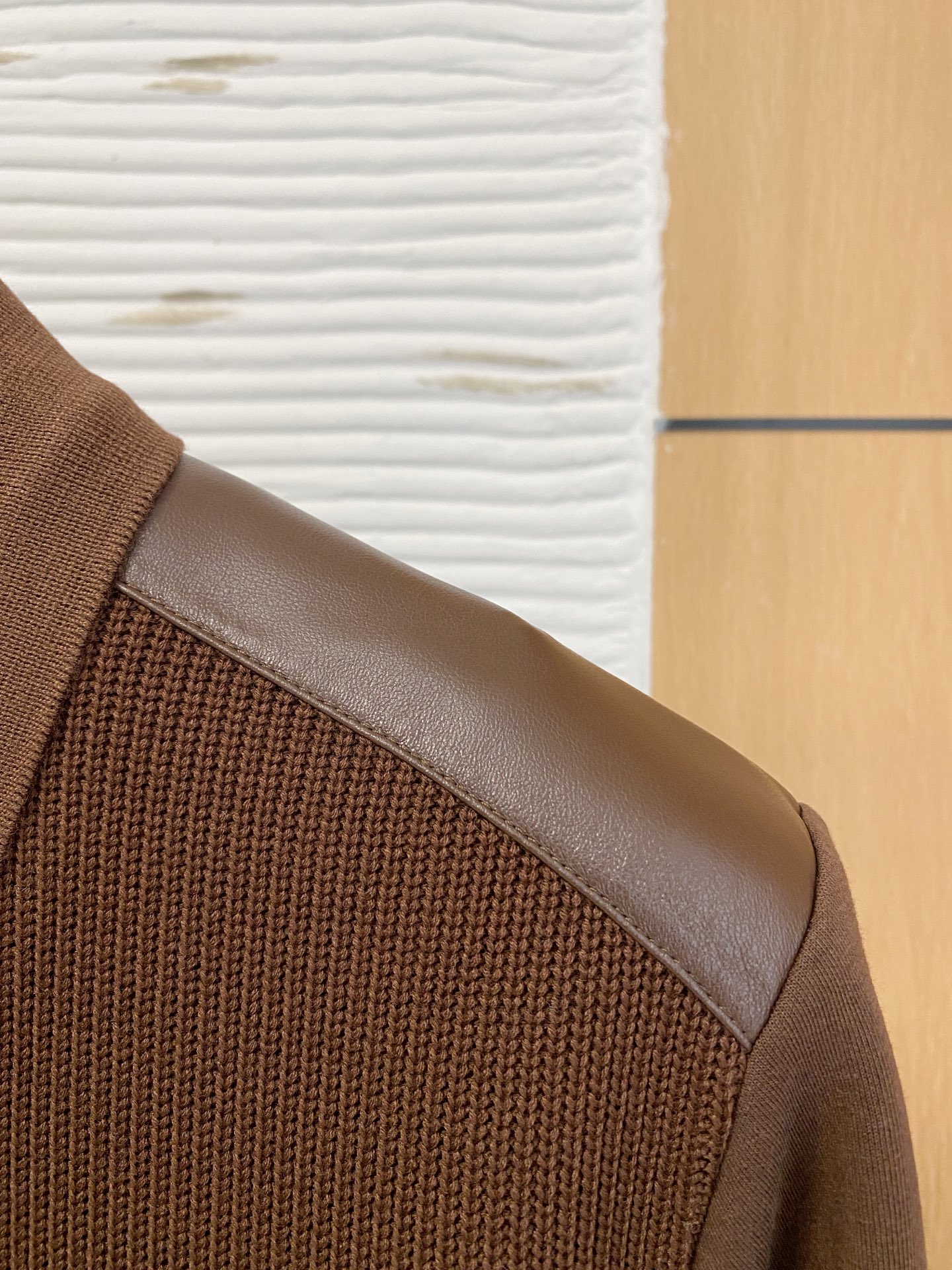 。普拉达 2025秋冬  羊毛混纺套头针织卫衣  几何拼皮的口袋设计 很有亮点，标志字母纽扣 细节上凸显