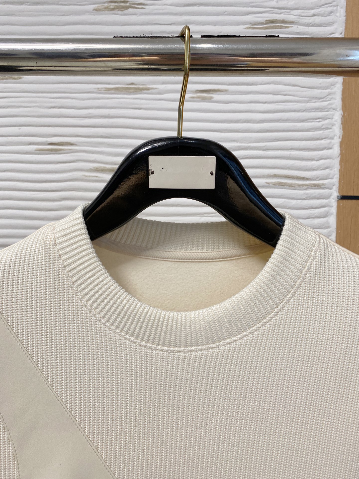 。普拉达 2025秋冬  羊毛混纺套头针织卫衣  几何拼皮的口袋设计 很有亮点，标志字母纽扣 细节上凸显