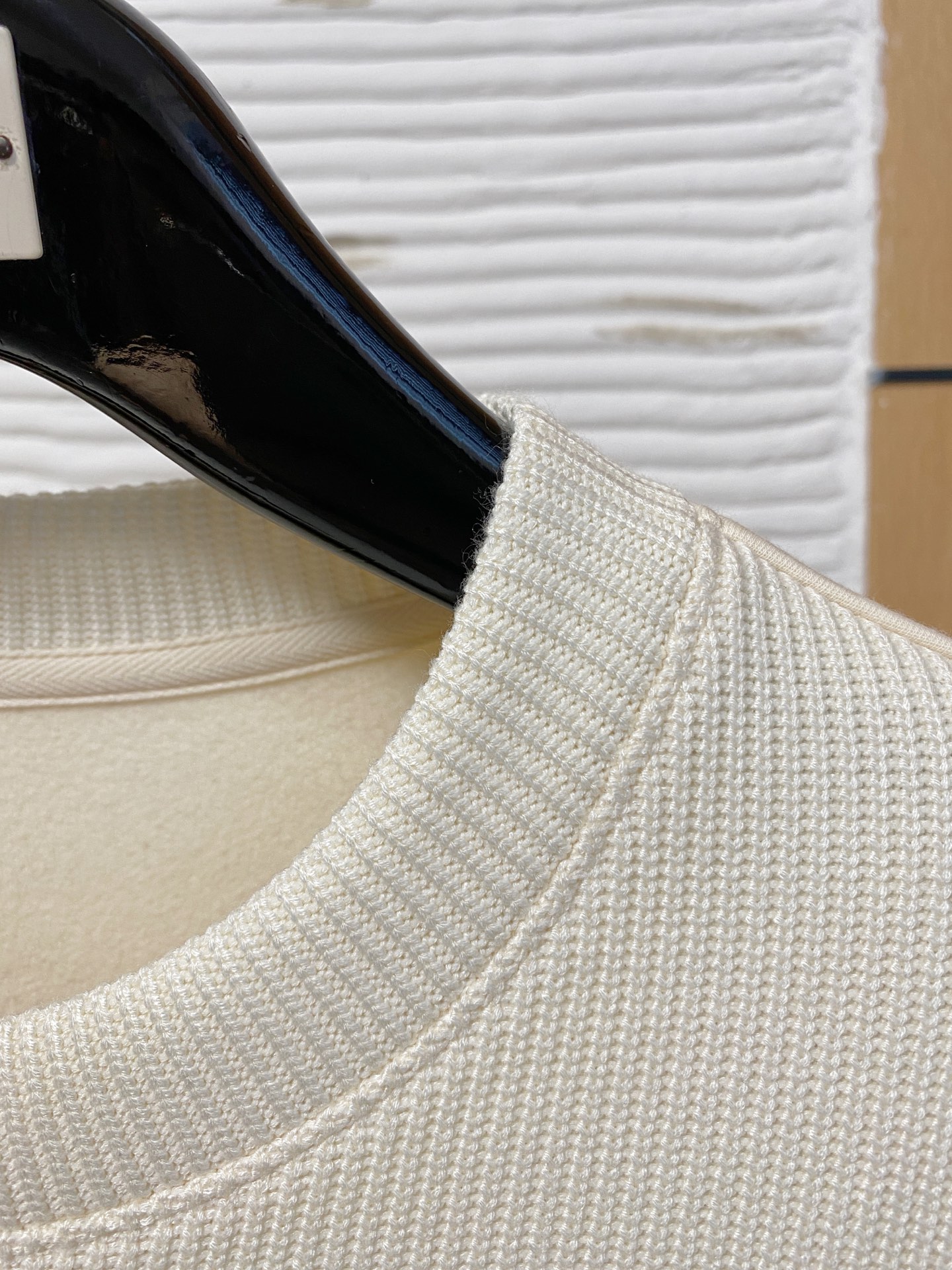 。普拉达 2025秋冬  羊毛混纺套头针织卫衣  几何拼皮的口袋设计 很有亮点，标志字母纽扣 细节上凸显